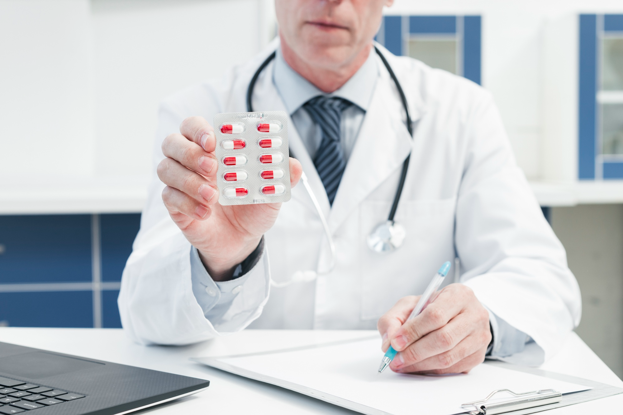 A healthcare professional provides an antibiotic prescription as part of appropriate medical treatment for infection.