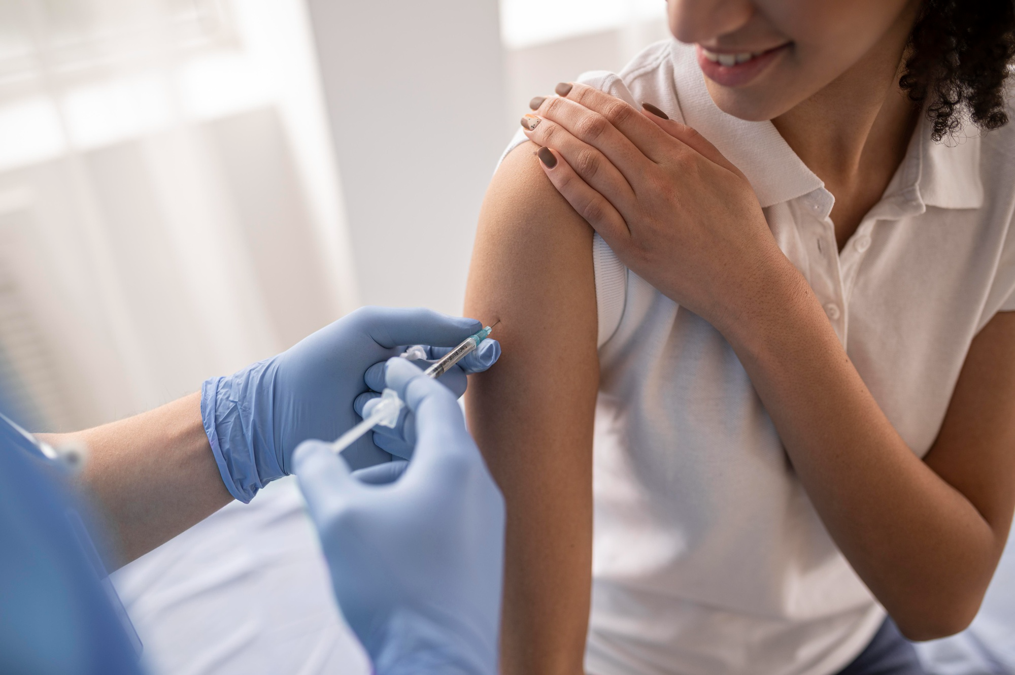 A woman receiving an injection from a healthcare professional during medical treatment.