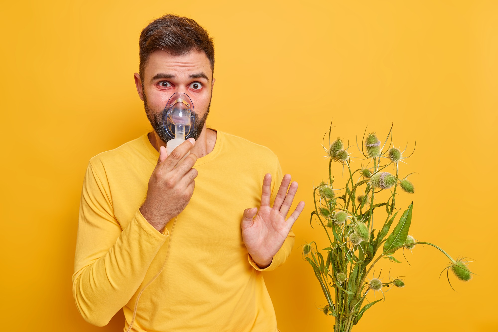 A man shielding his face from airborne pollen.