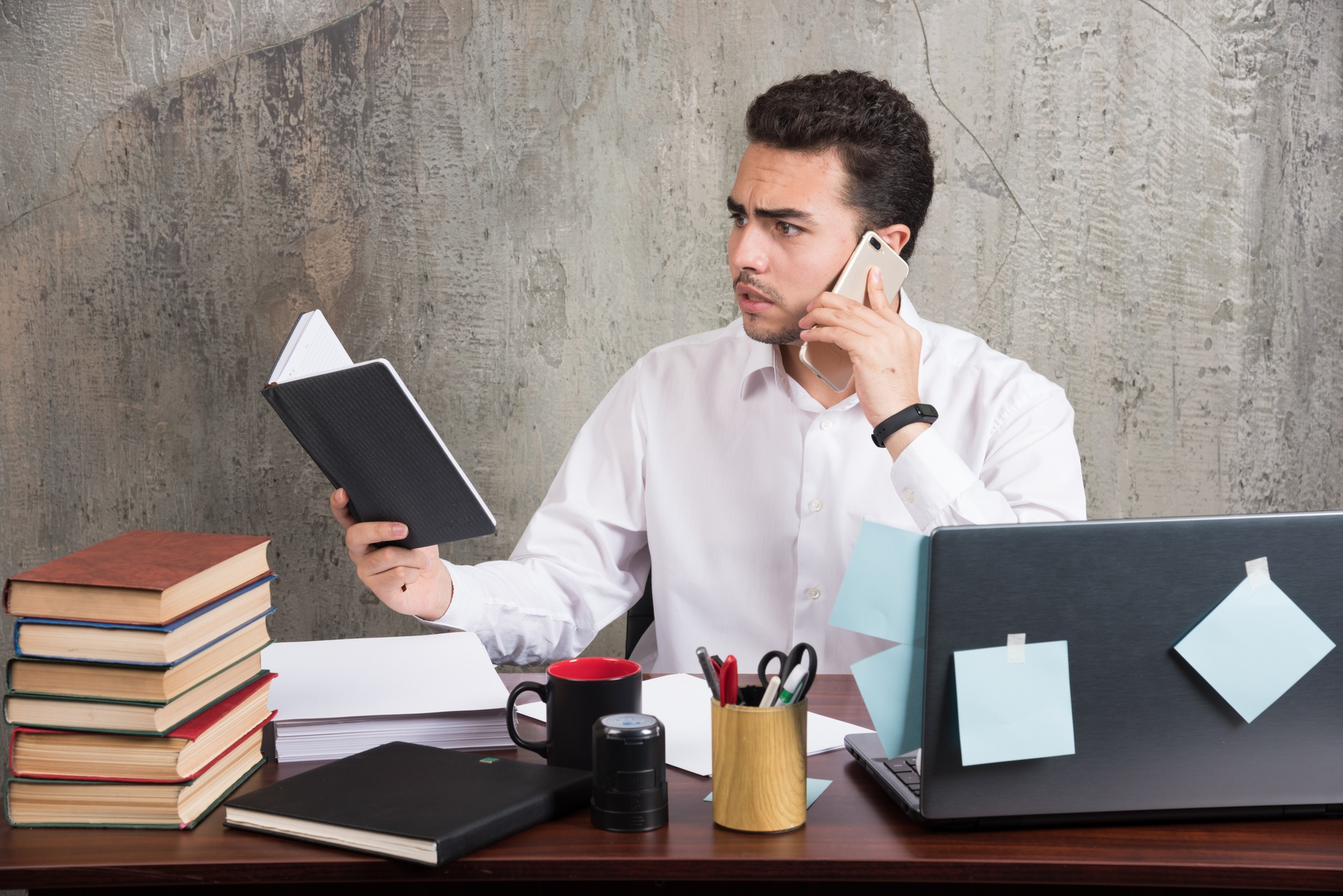 A man appearing overwhelmed while handling multiple tasks at once, illustrating stress, mental overload, and reduced focus caused by multitasking.