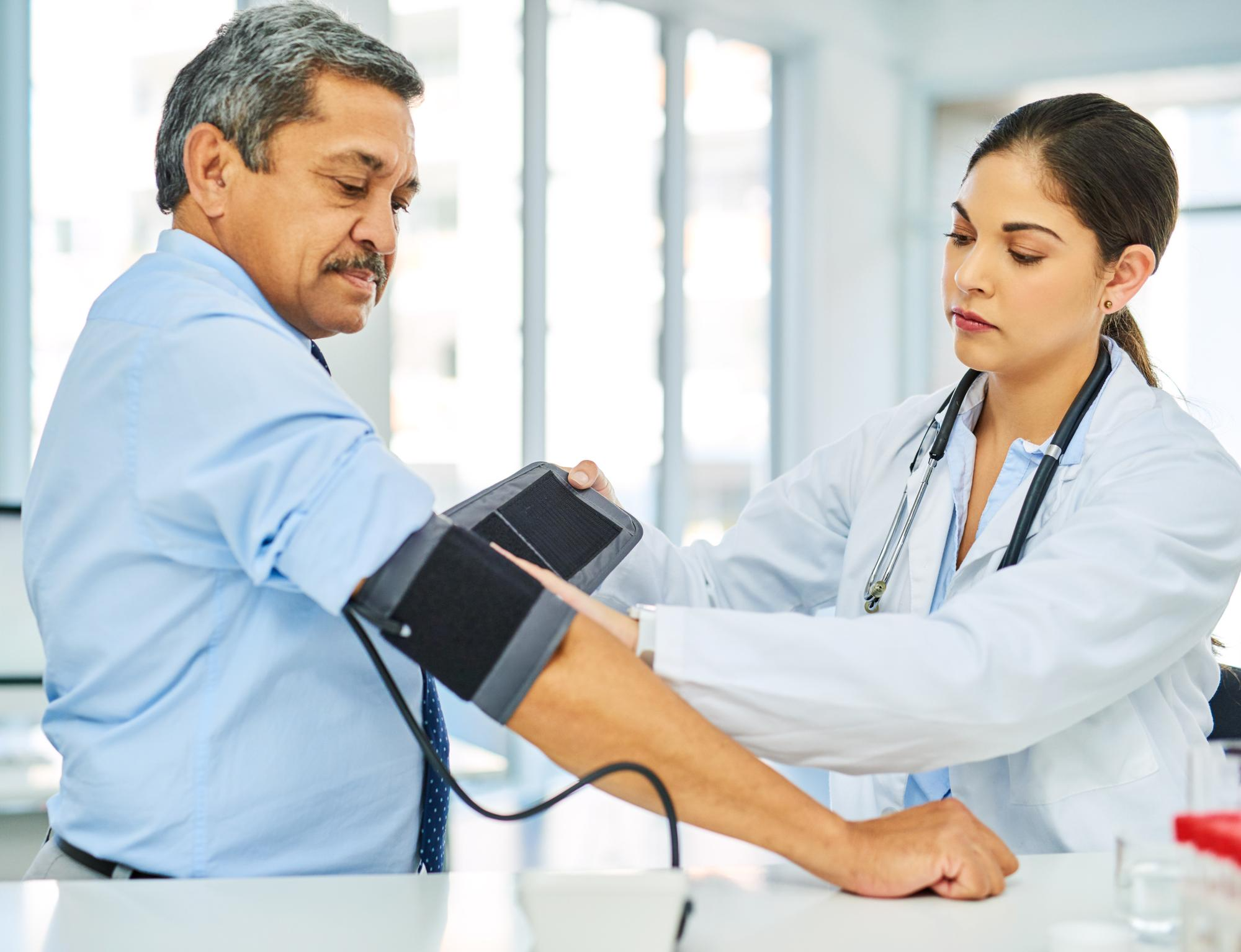 Doctor checking a patient’s blood pressure during a health check-up.