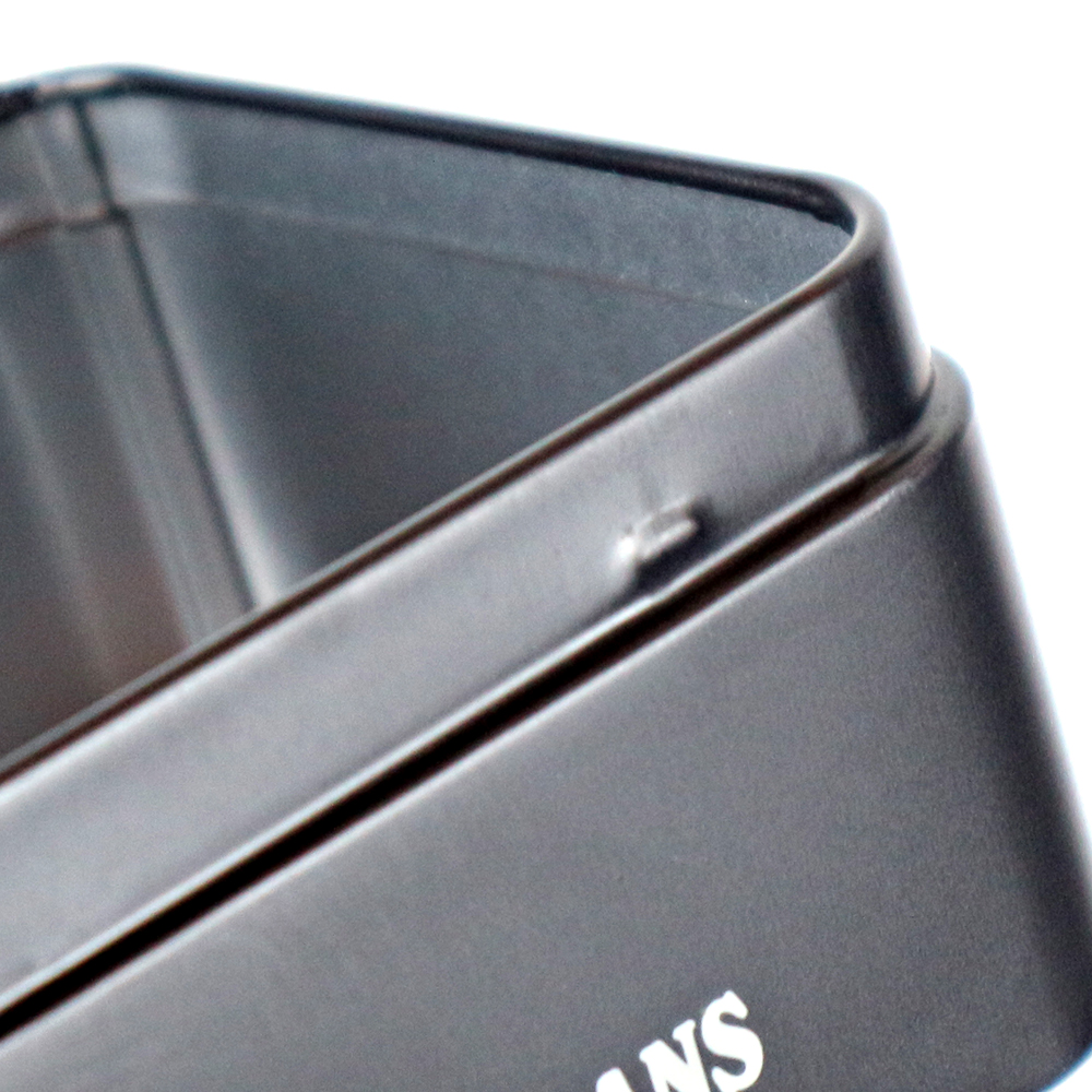 Close-up of a hinged lid on an embossed metal tin box