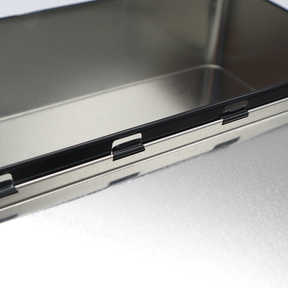 Rectangular tin box open with billiard chalk set inside.