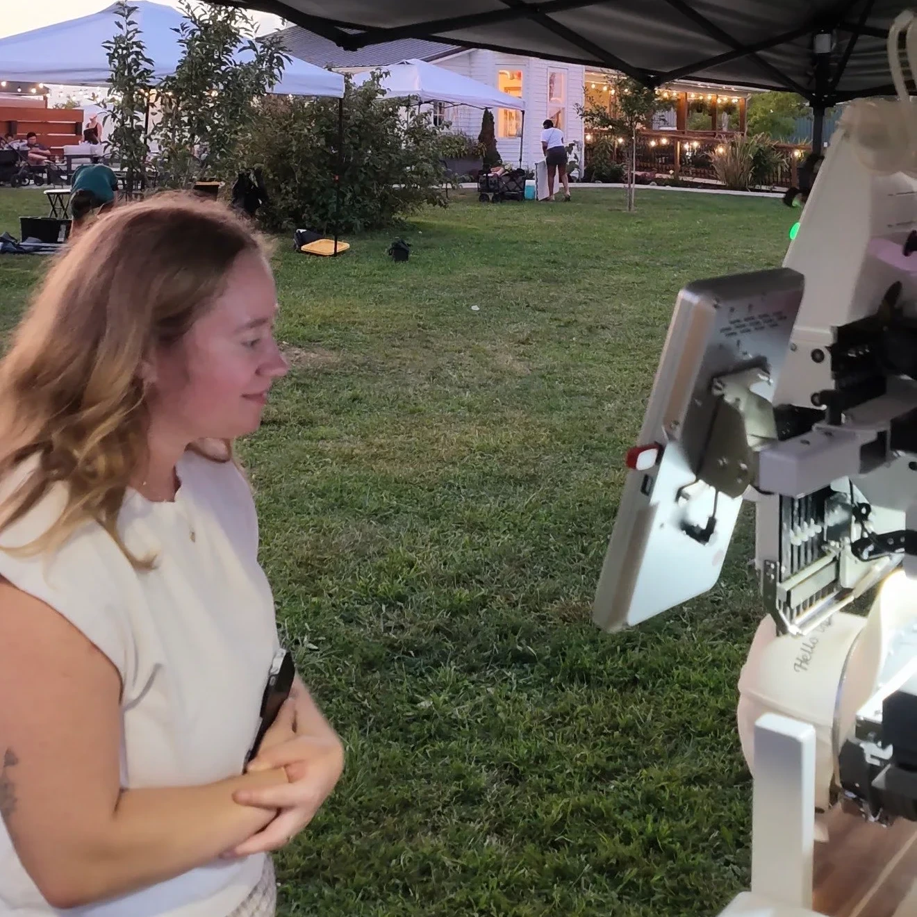 Customer watching her cap get embroidered live on the PrintStitch machine at Solara Market