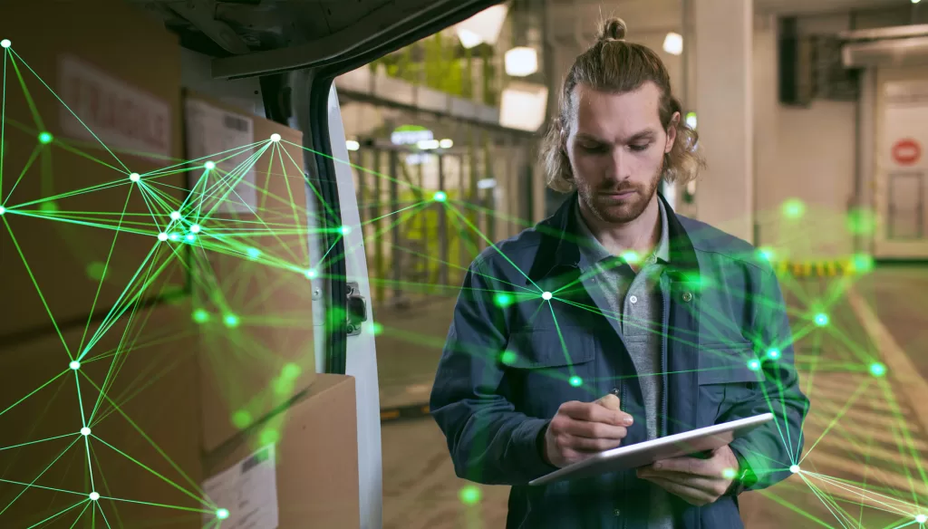 man with tablet next to van with boxes green plexus overlayed