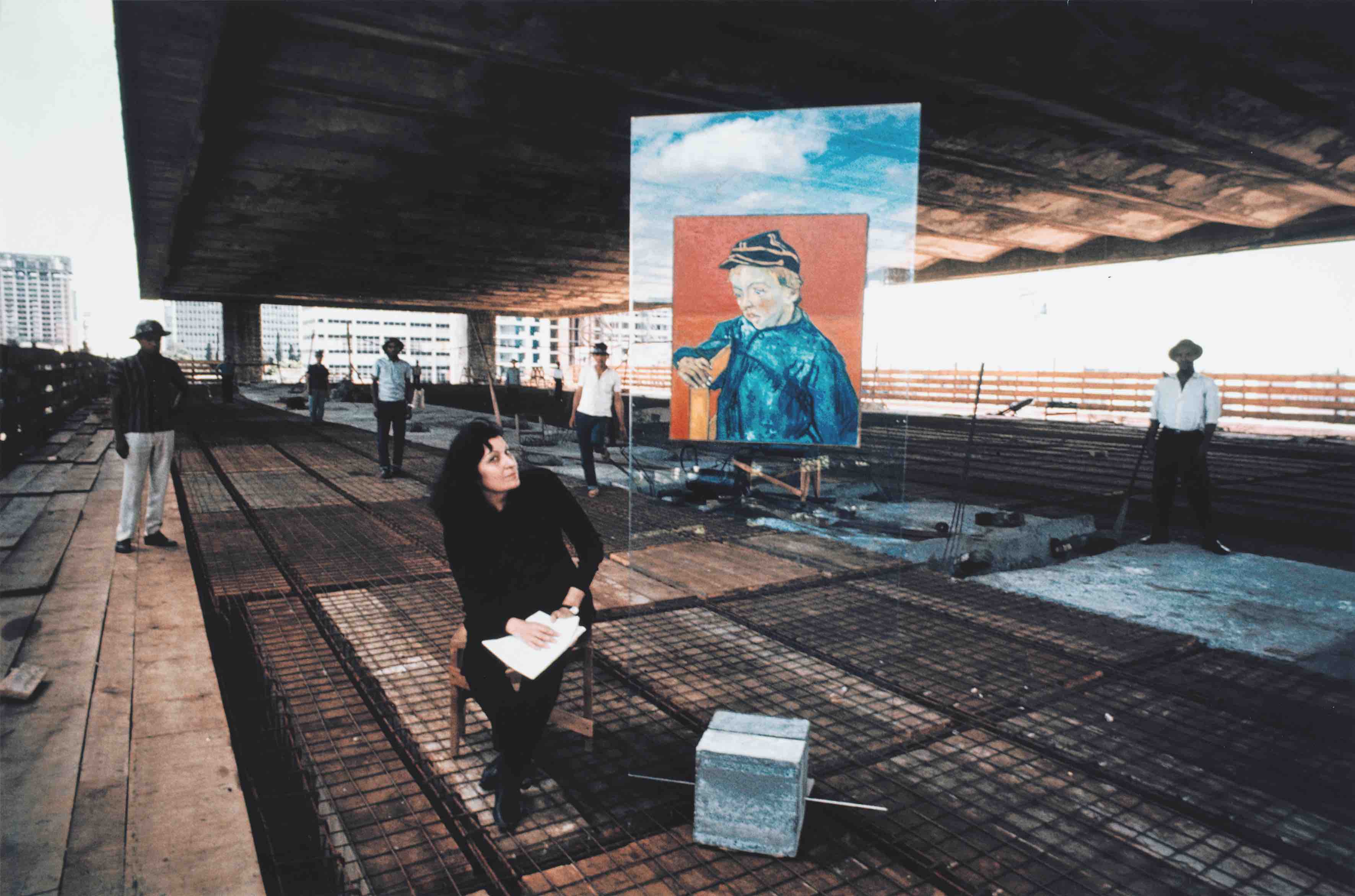 Lina Bo Bardi en la construcción del MASP en Avenida Paulista junto al prototipo del caballete de vidrio con la reproducción de El estudiante de Vincent van Gogh en 1967. Colección Instituto Bardi / Casa de Vidro São Paulo. Fotografía: Lew Parrella 