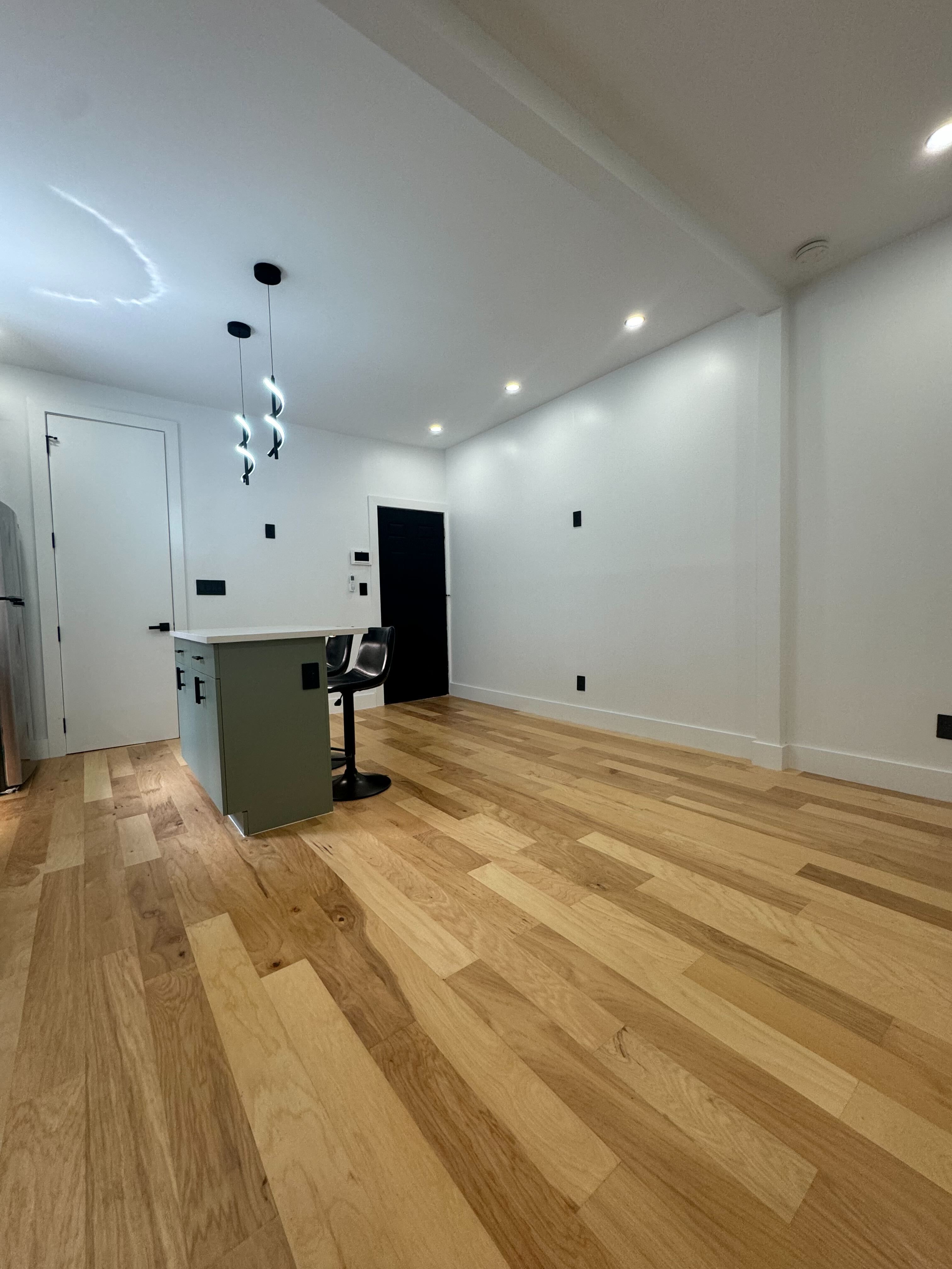 Newly remodeled basement room with light wooden flooring