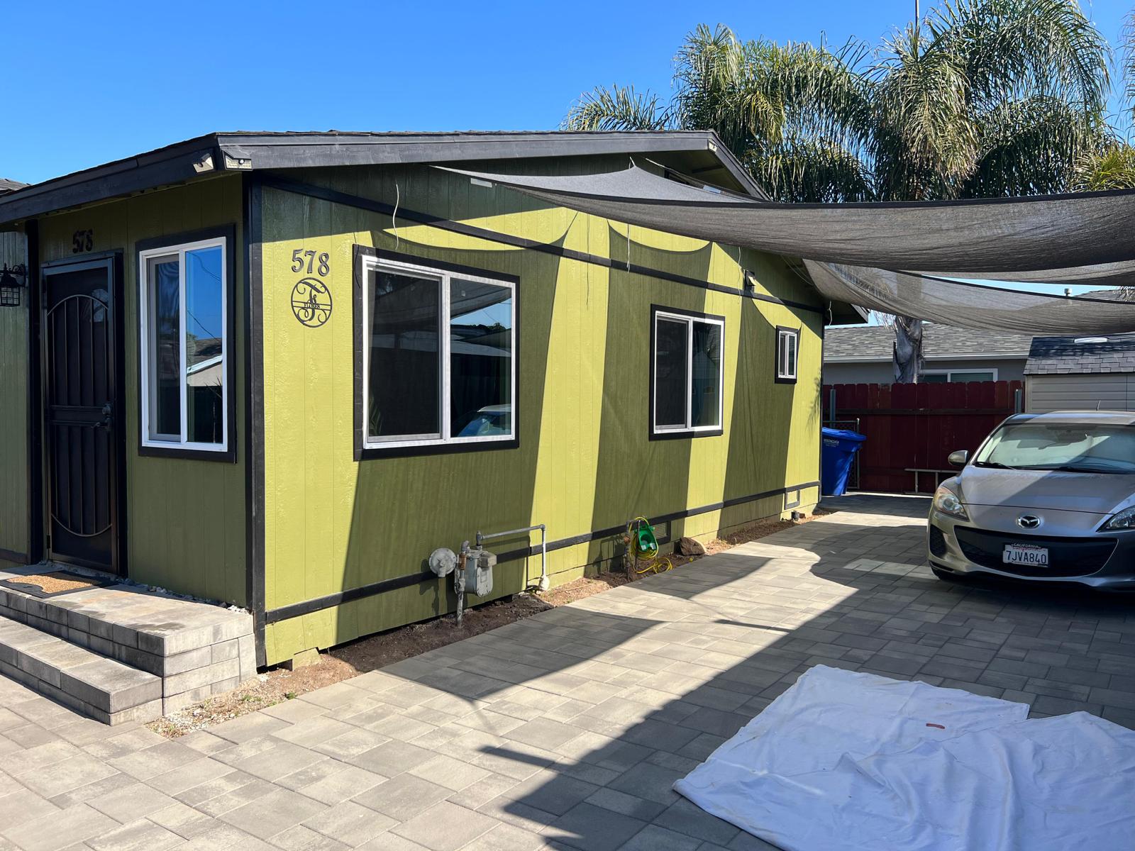 Exterior view of a house with green siding under renovation