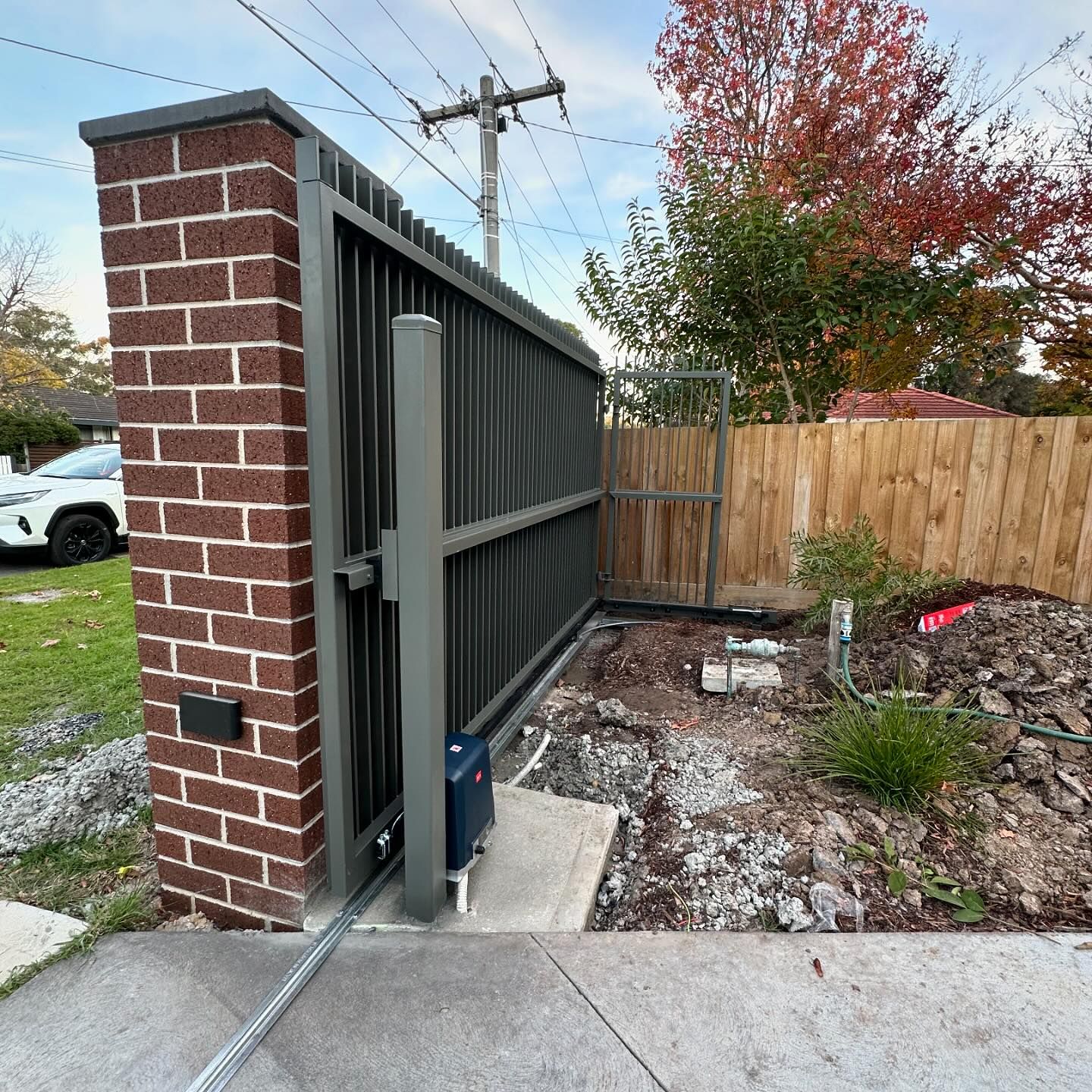Automated sliding gate integrated into steel blade fence