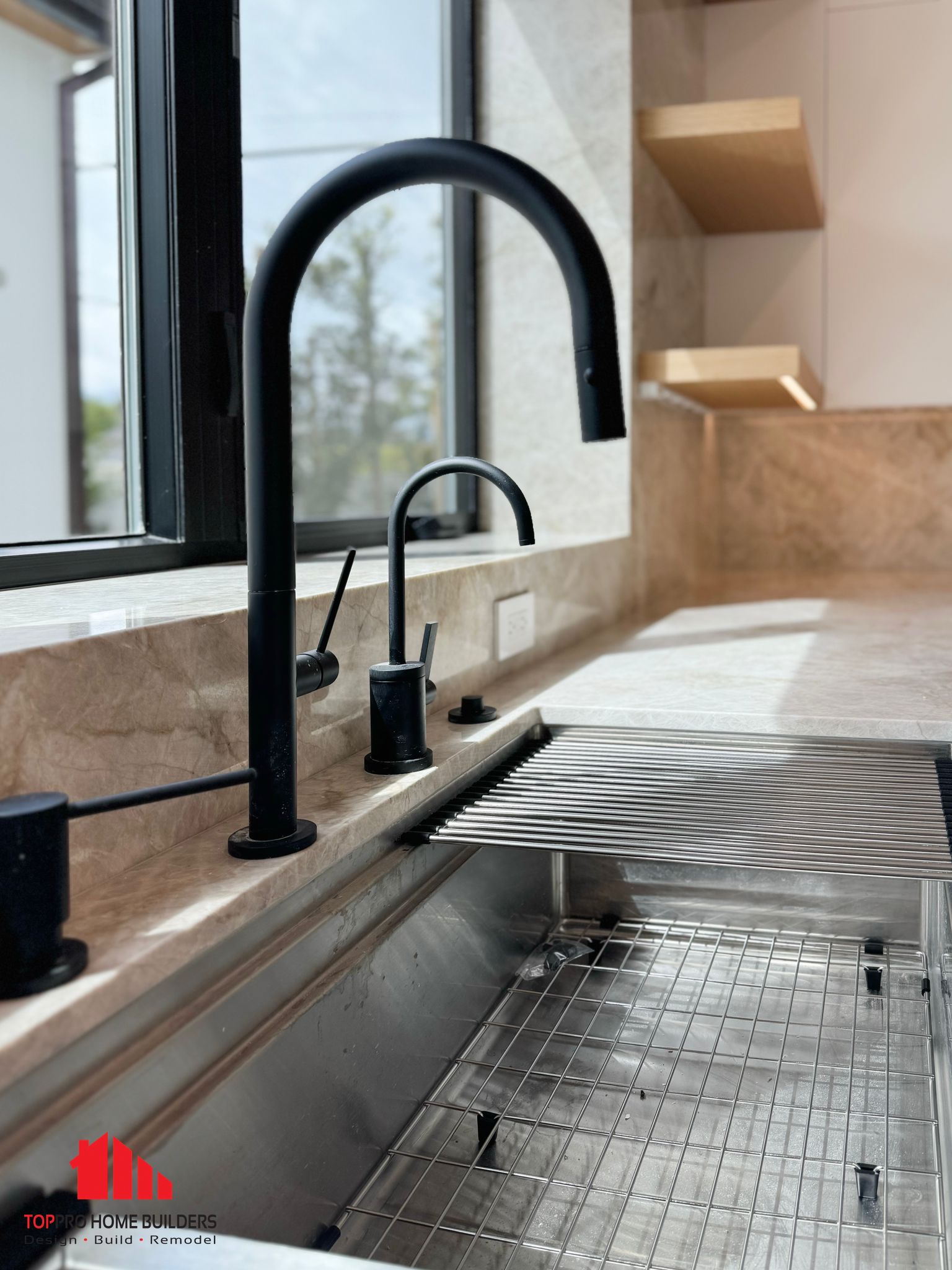 Modern kitchen sink featuring stainless steel basin and black matte faucet