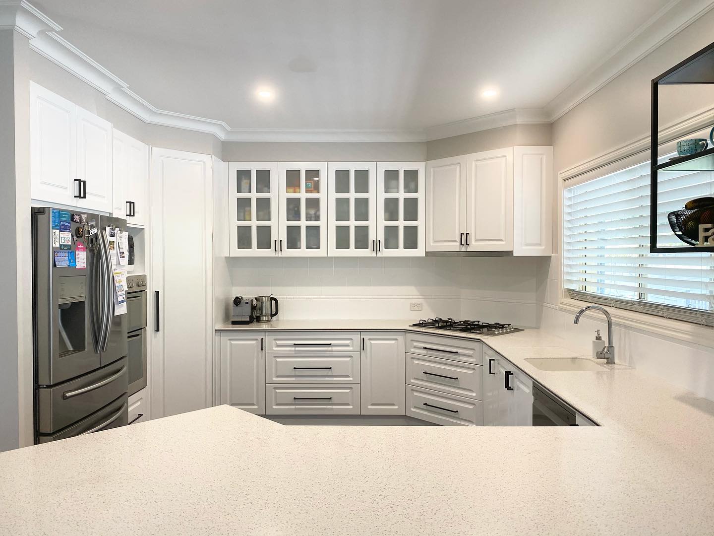 Modern kitchen with white cabinetry post-resurfacing