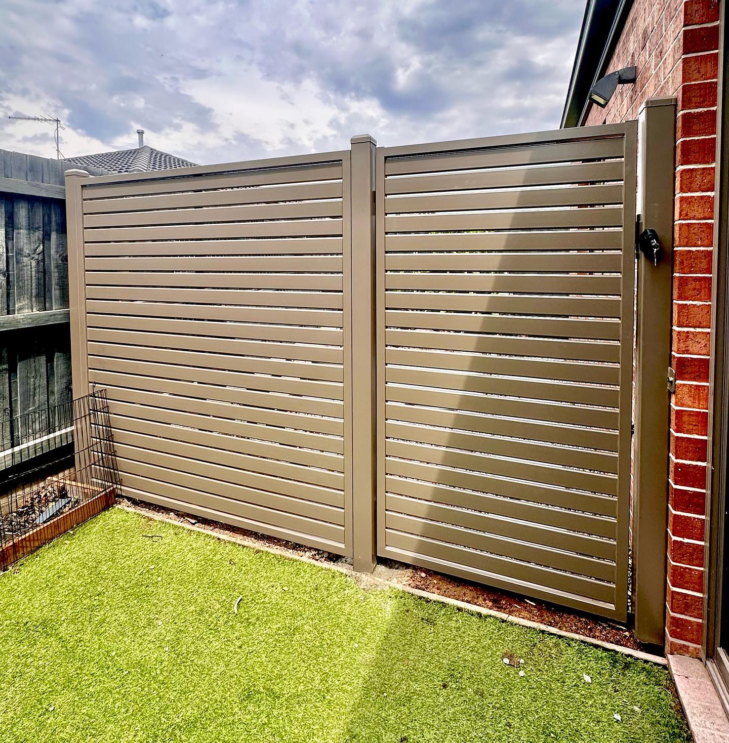 Beige steel slat fence panels with gate
