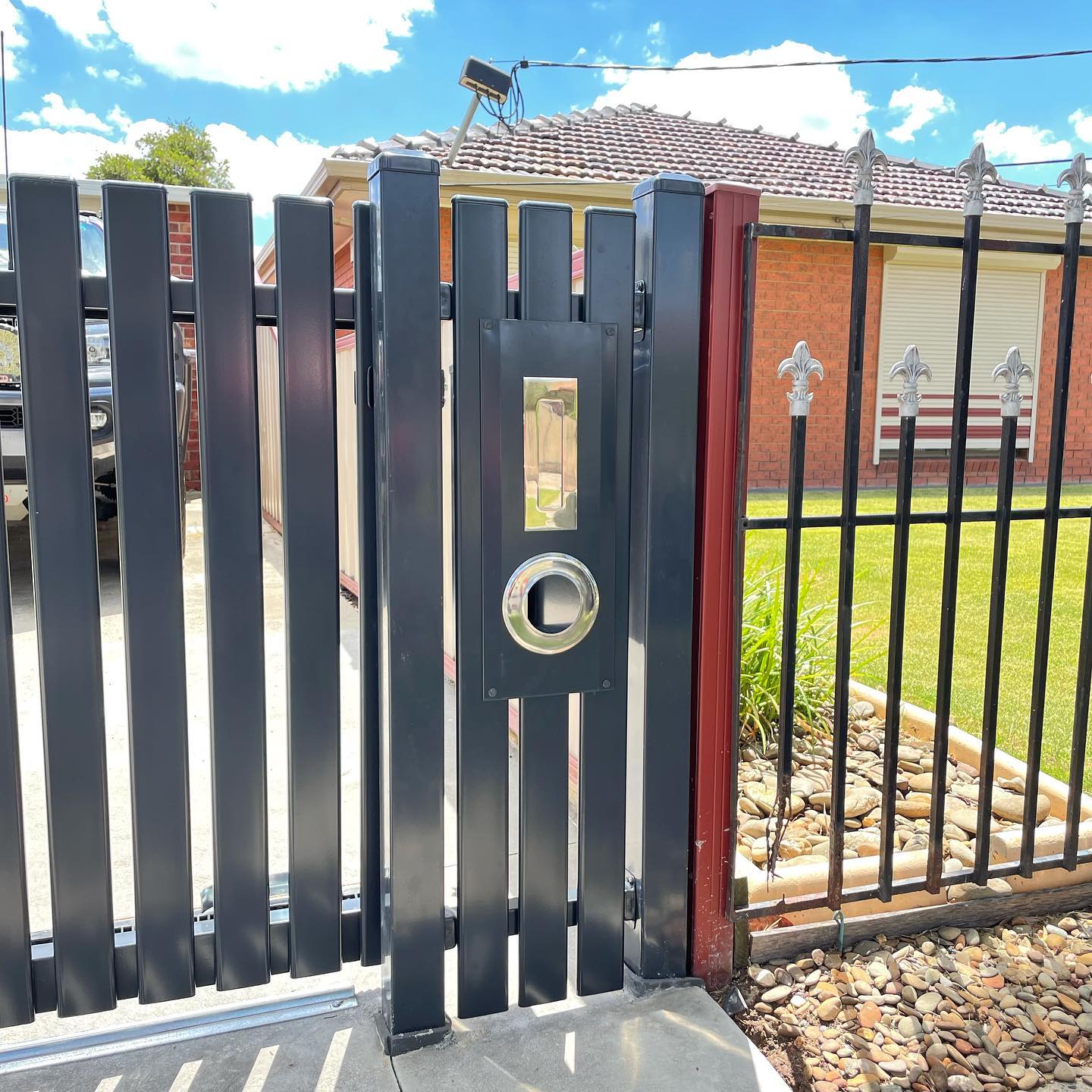 Modern black metal gate with integrated mailbox slot