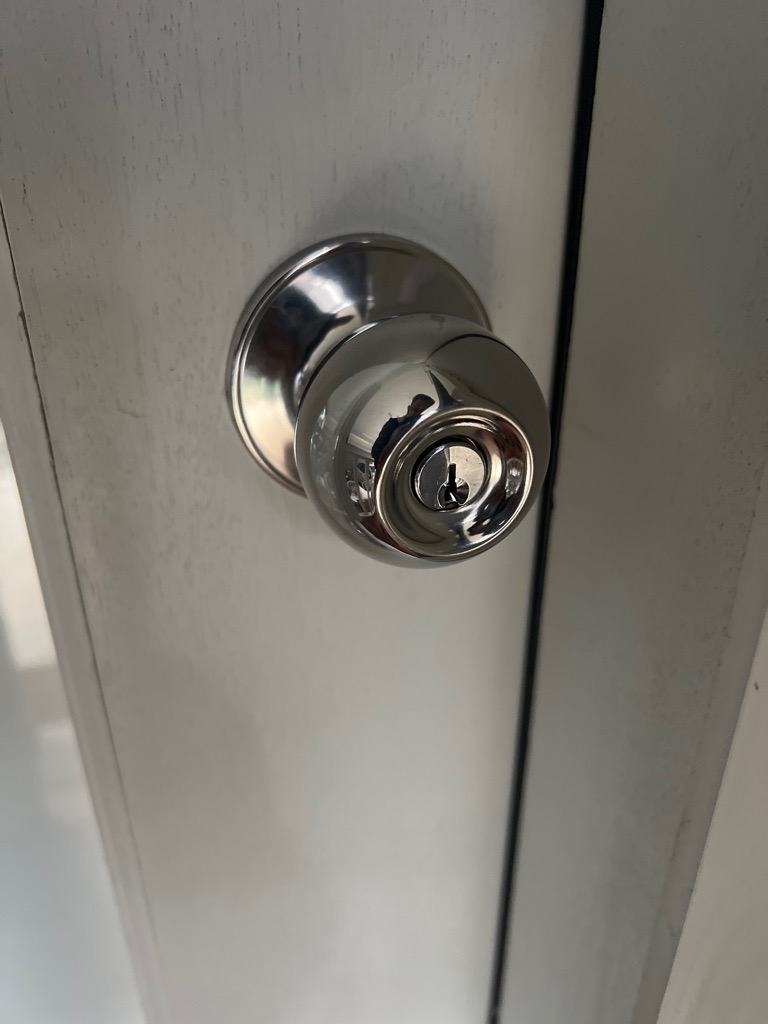 Door knob with integrated keyhole on a white wooden door