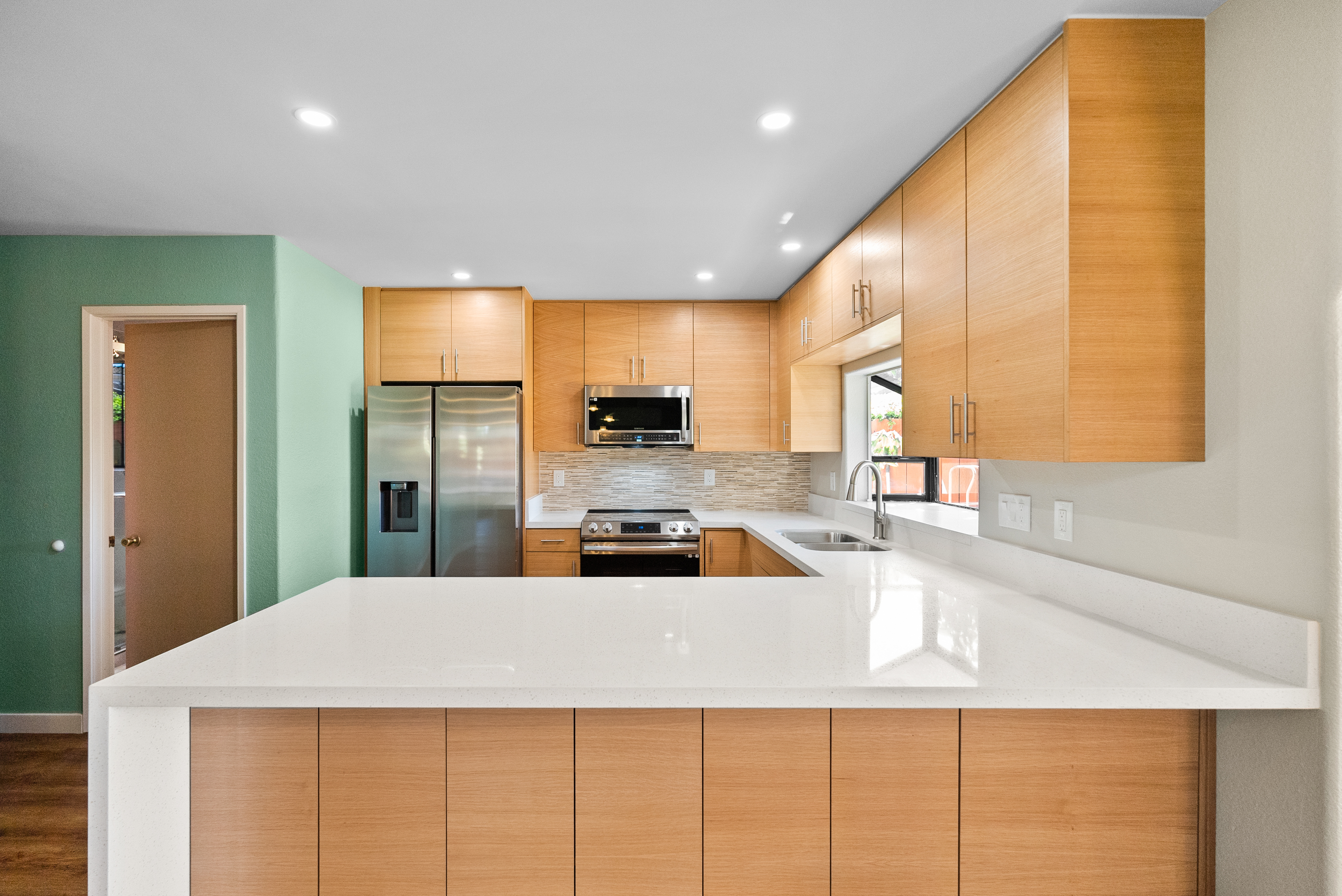 Modern kitchen featuring wooden cabinets and white countertops