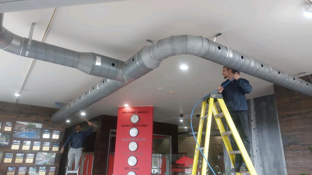 Technicians working on an overhead duct system