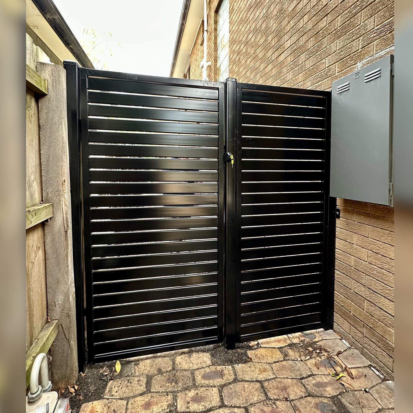 Black slat steel fence with lock mechanism