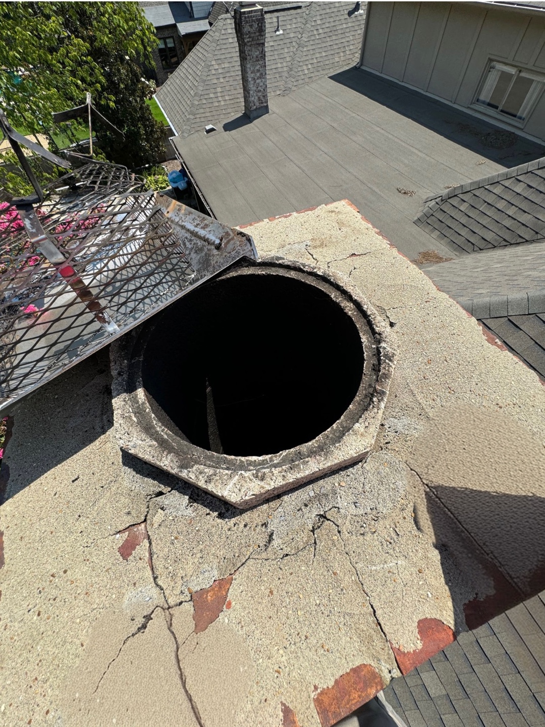 Damaged chimney with visible cracks and deterioration on the top surface