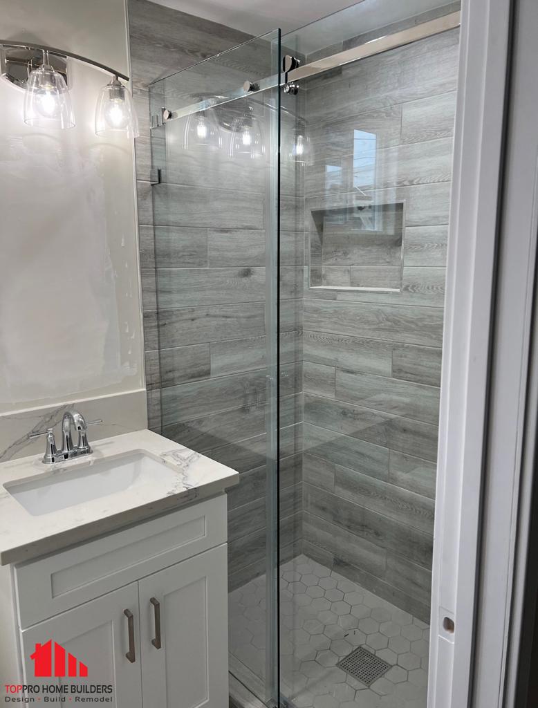 Modern bathroom remodel featuring glass shower enclosure and elegant vanity