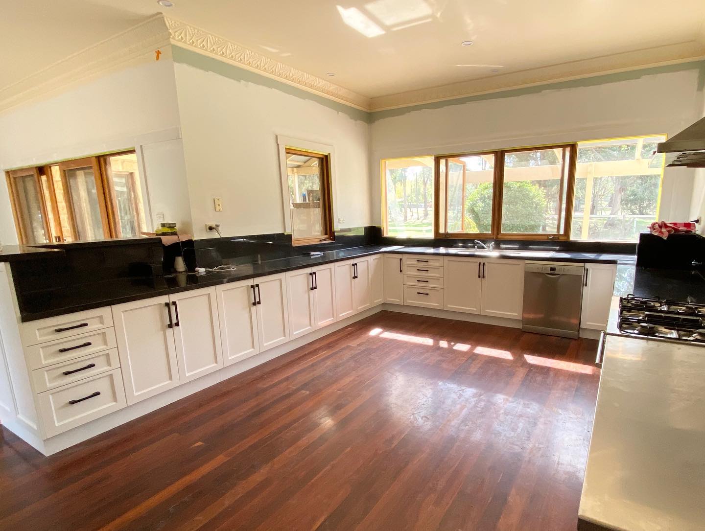 Kitchen with white cabinetry and black countertops