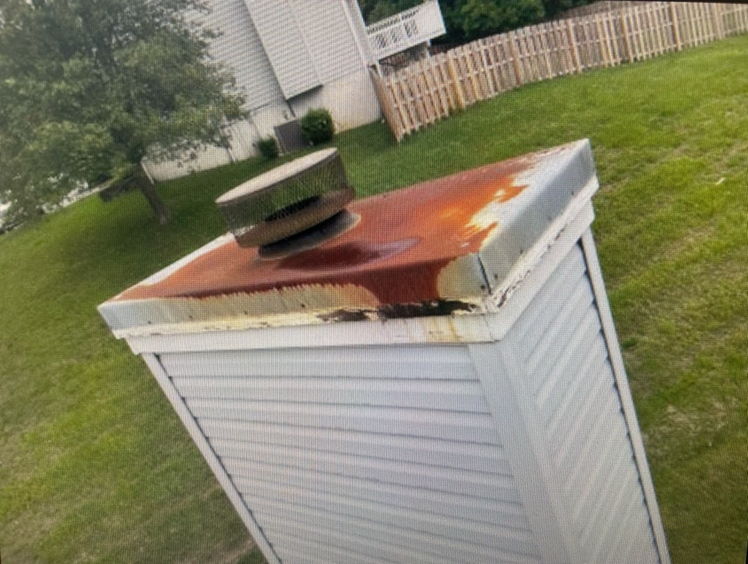 Rusted chase cover on top of a chimney structure