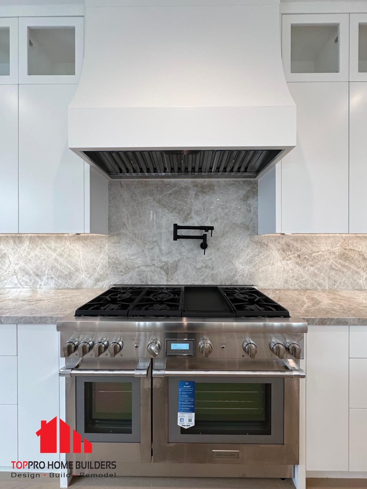 Modern kitchen featuring stainless steel appliances and elegant backsplash