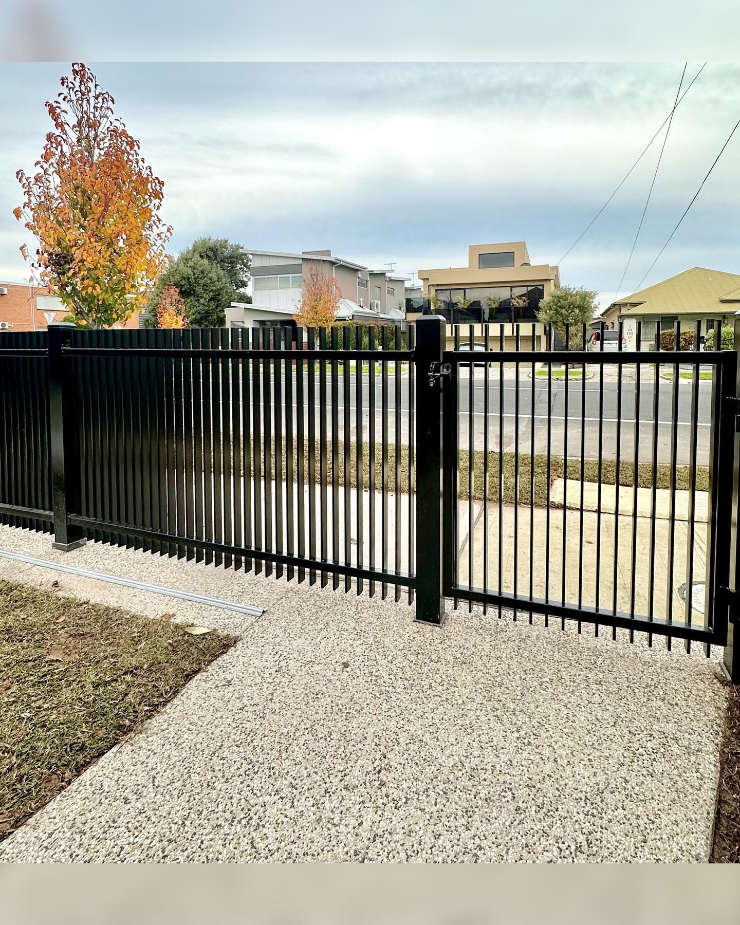 Black metal blade fence with vertical bars