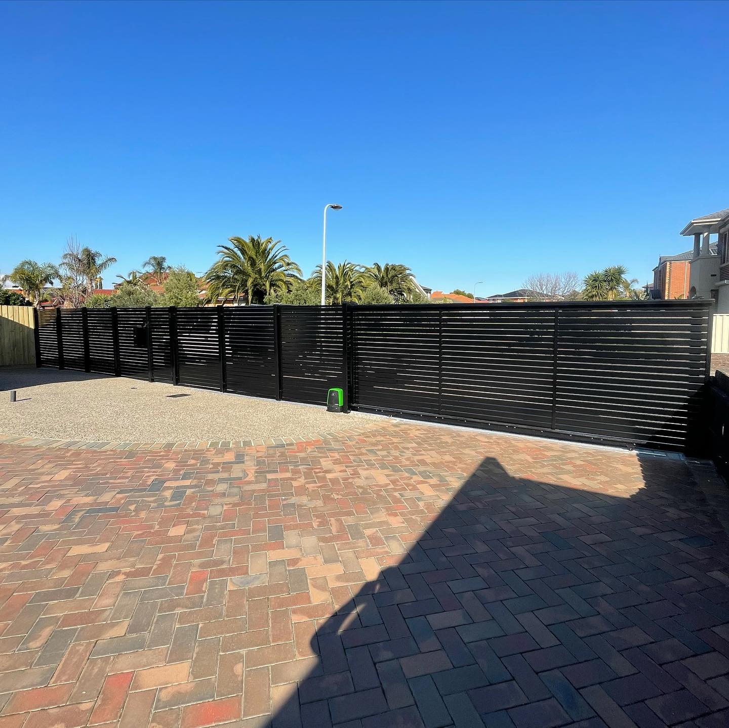 Black slat fence with sliding gate