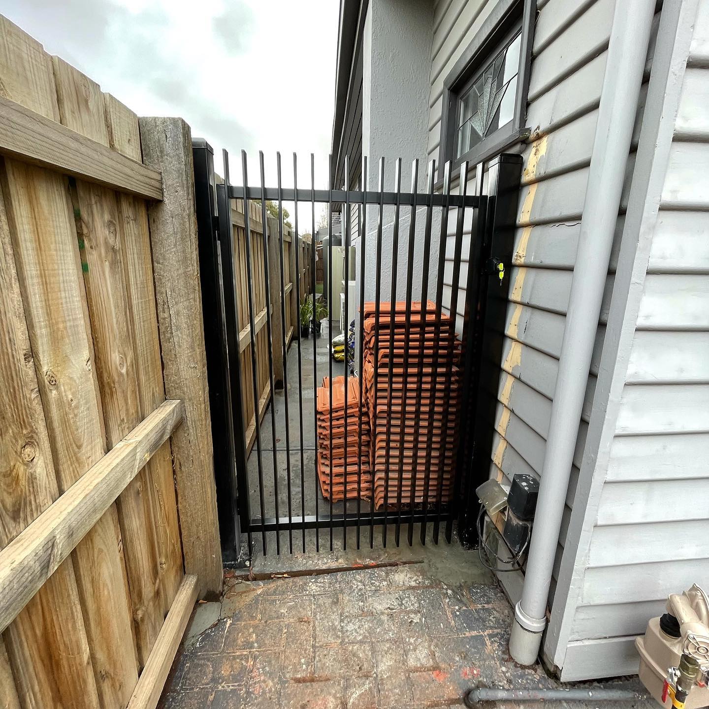 Stunning Satin Black Blade Style Fence with Chrome Accessories in Northcote 2 Black blade style fence with vertical bars and gate