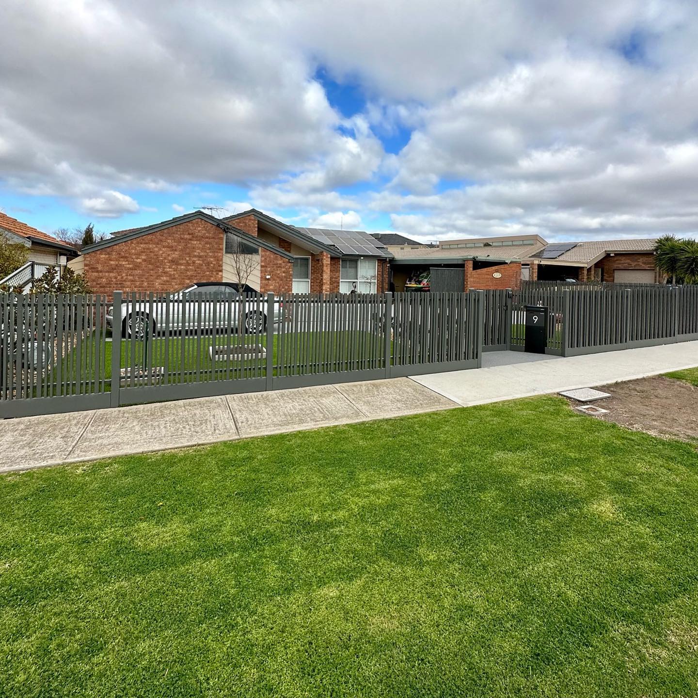 Completed slat blade fence enclosing front yard