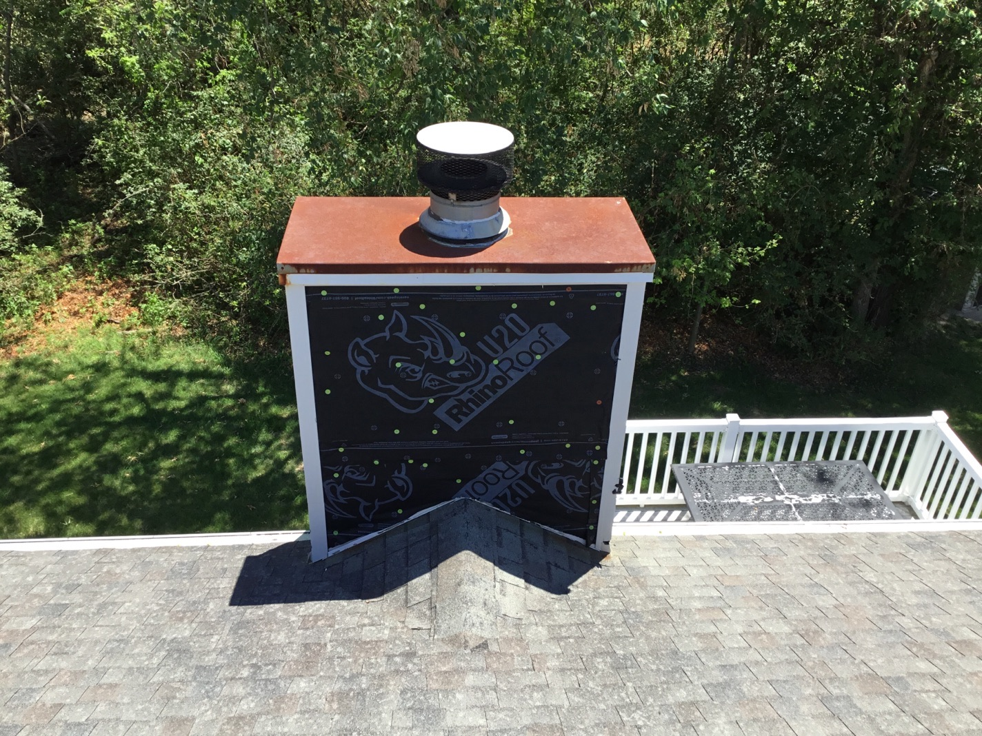 Newly installed metal chase top on chimney wrapped in RhinoRoof underlayment