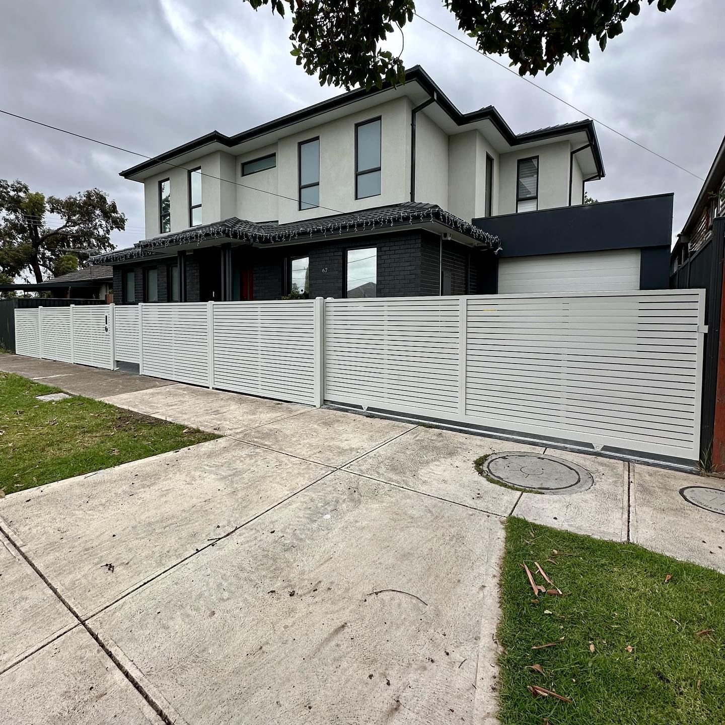 Modern house with white steel slat fence providing privacy