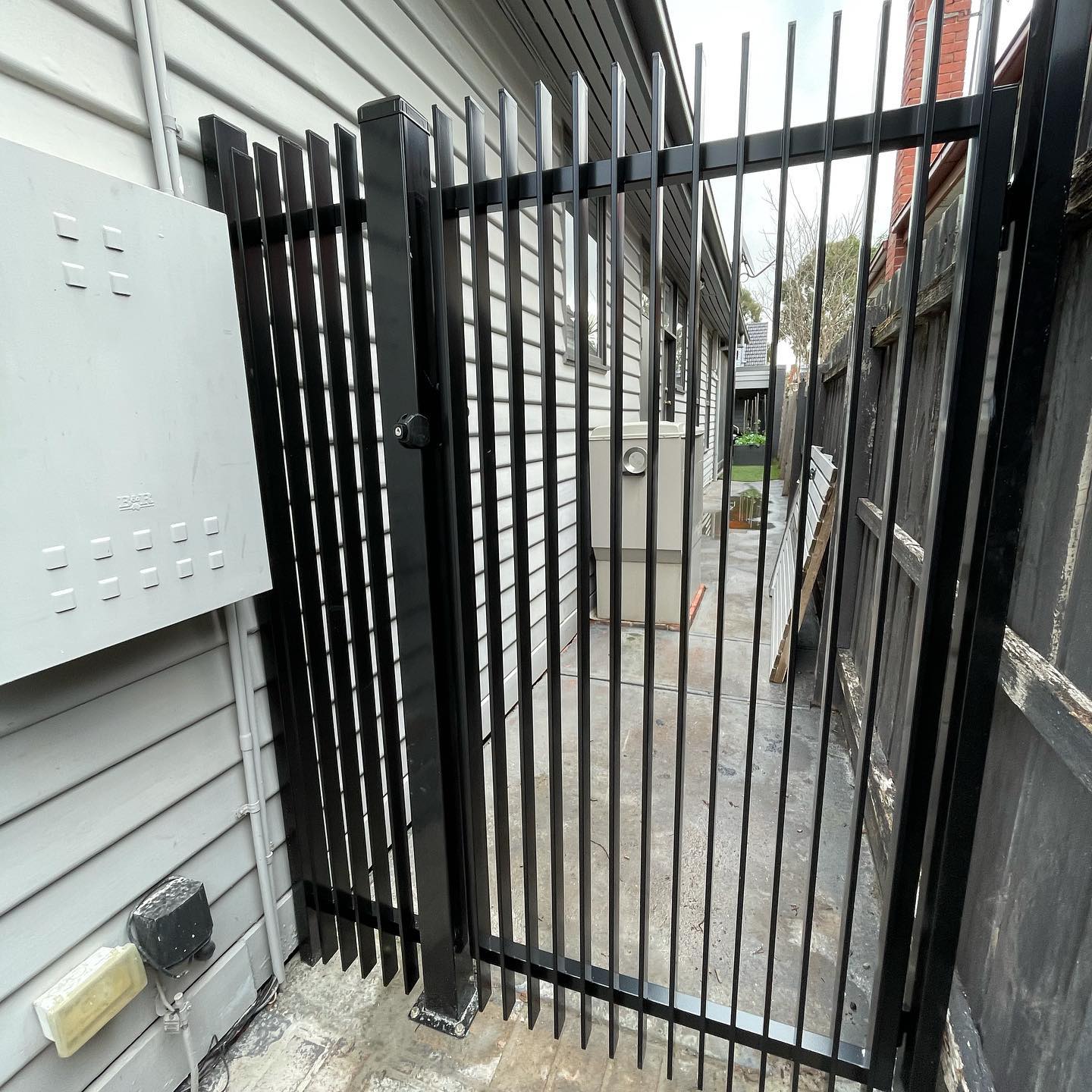 Stunning Satin Black Blade Style Fence with Chrome Accessories in Northcote 4 Satin black blade style fence along house wall