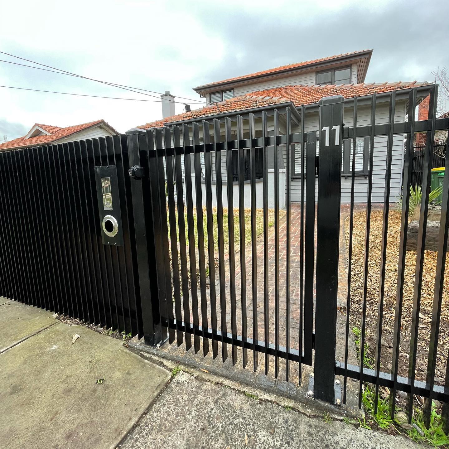 Black metal fence with intercom system