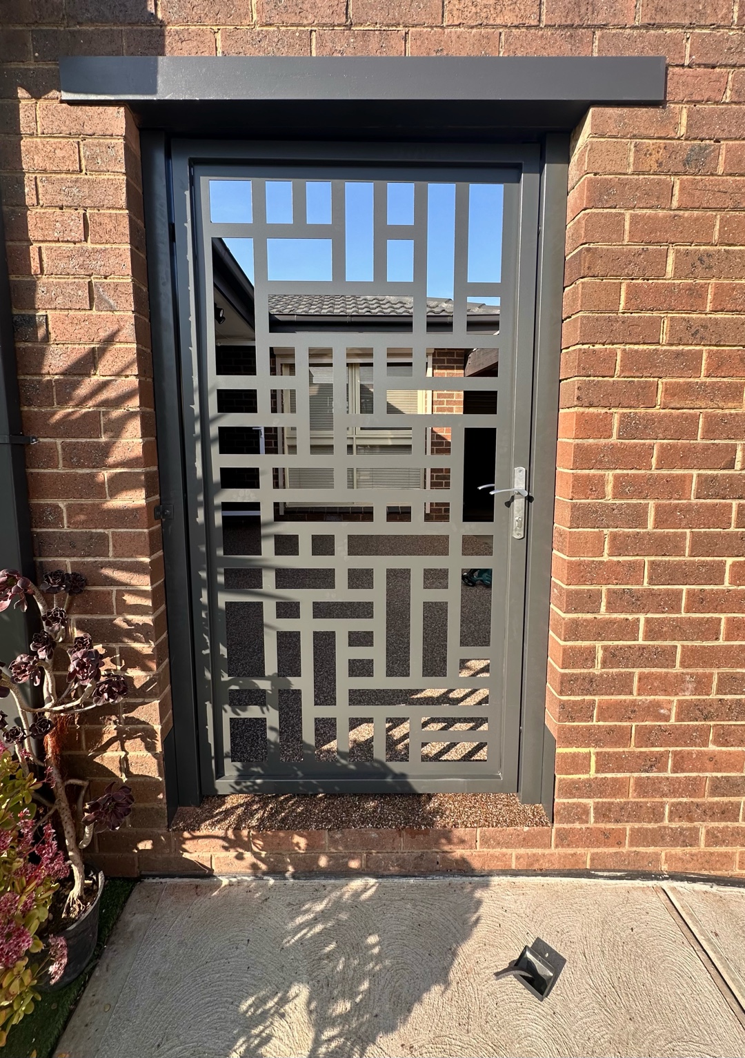 Steel door with geometric laser-cut design centered in frame