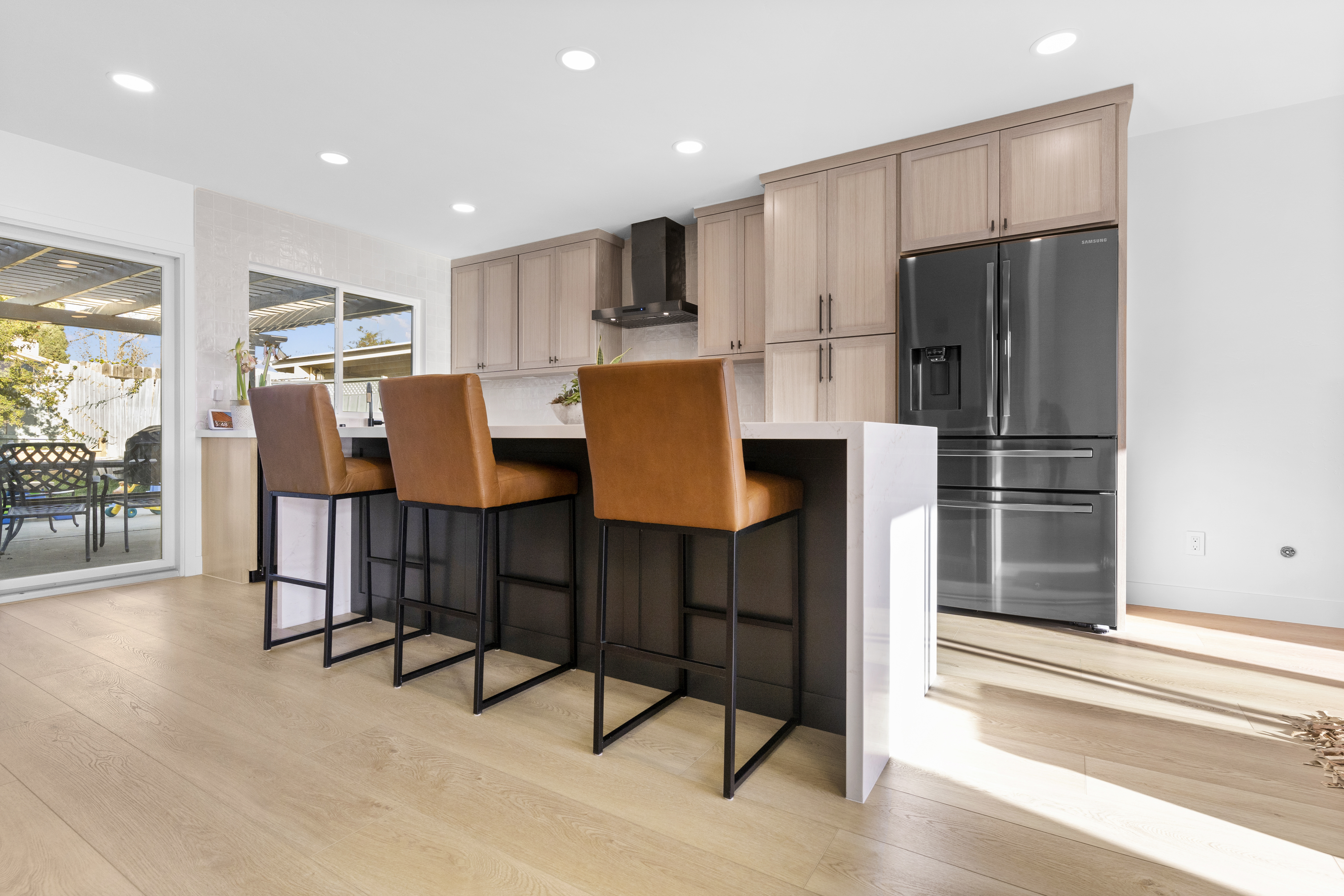 Modern kitchen interior with natural light streaming in through a sliding glass door