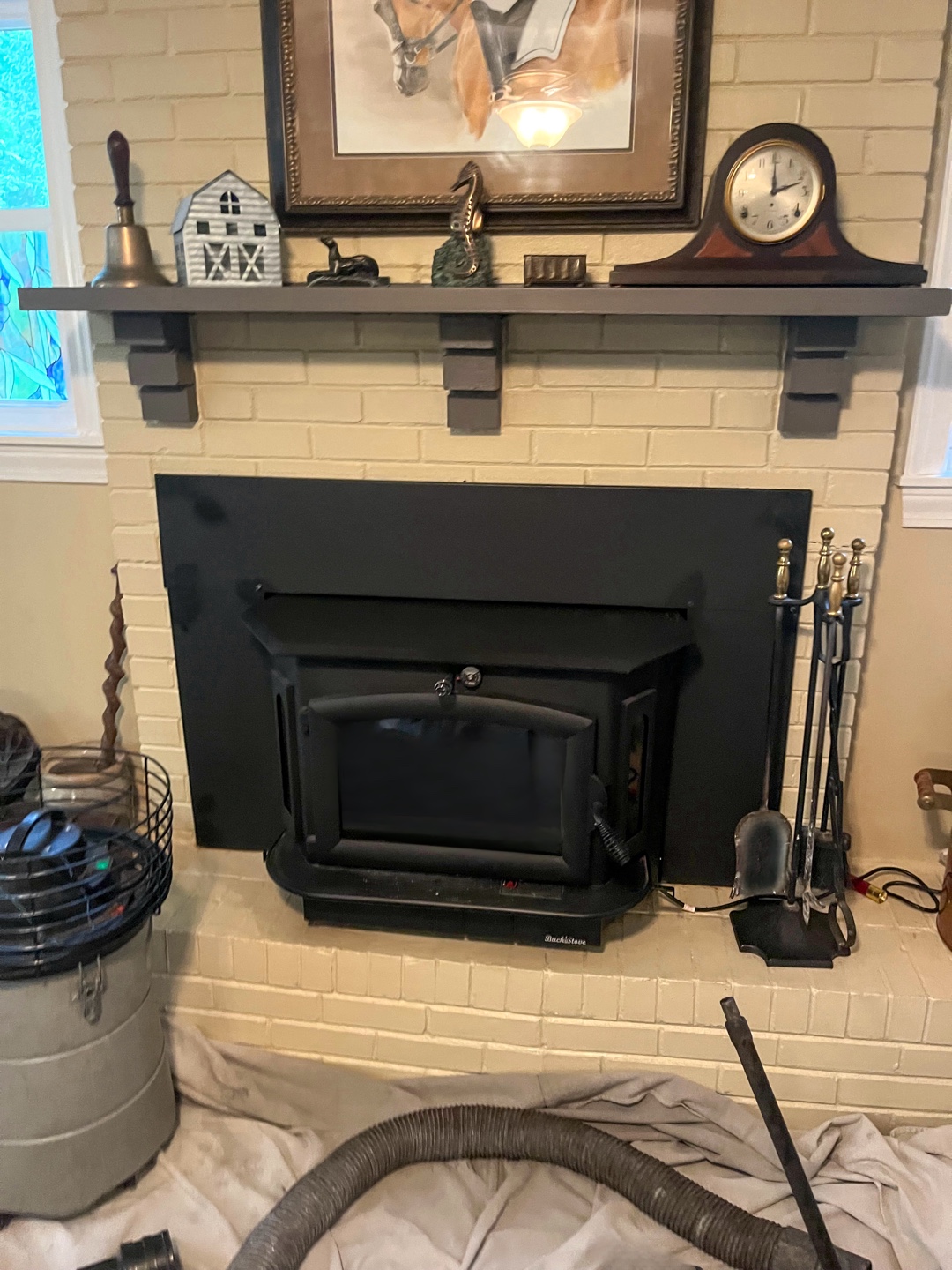 New black pellet stove installed in brick fireplace