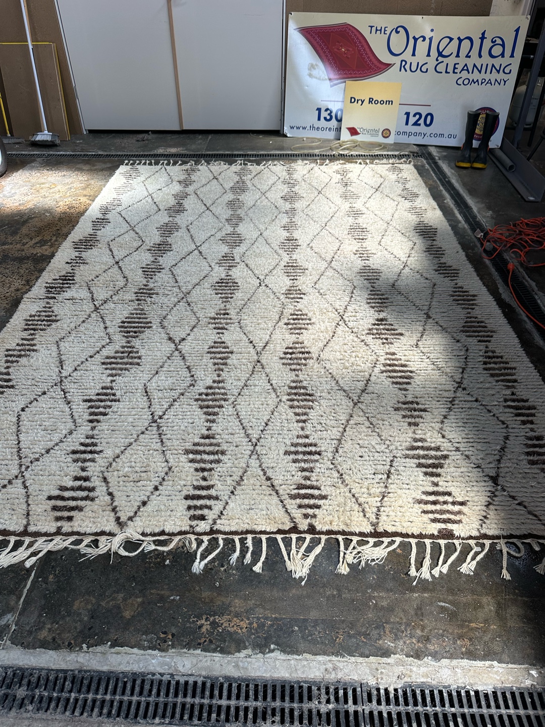 Rug laid out on concrete floor during drying process
