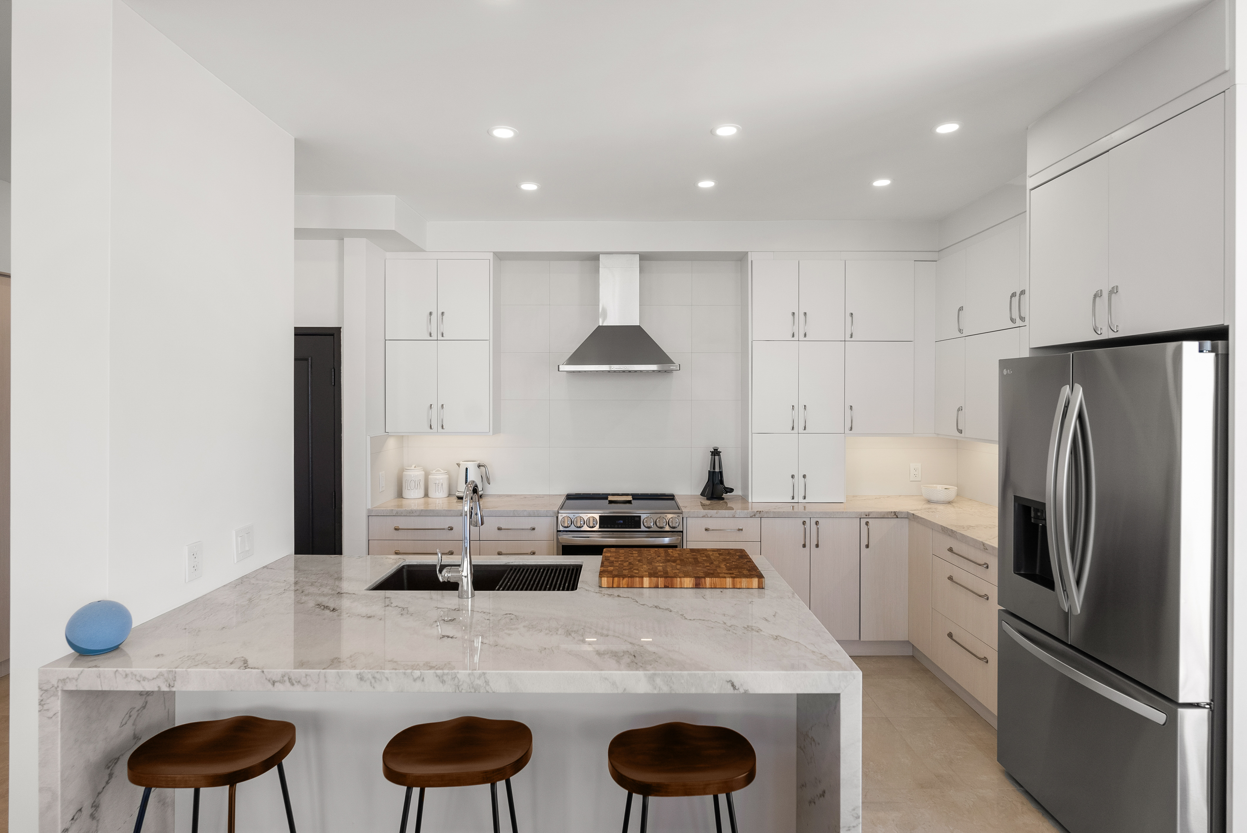 Modern kitchen featuring white quartz countertops and light wood cabinetry