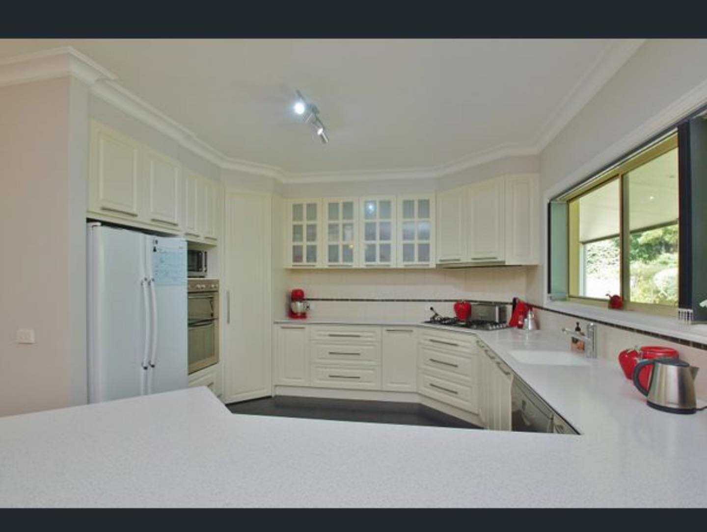 Modern kitchen with white cabinetry after resurfacing