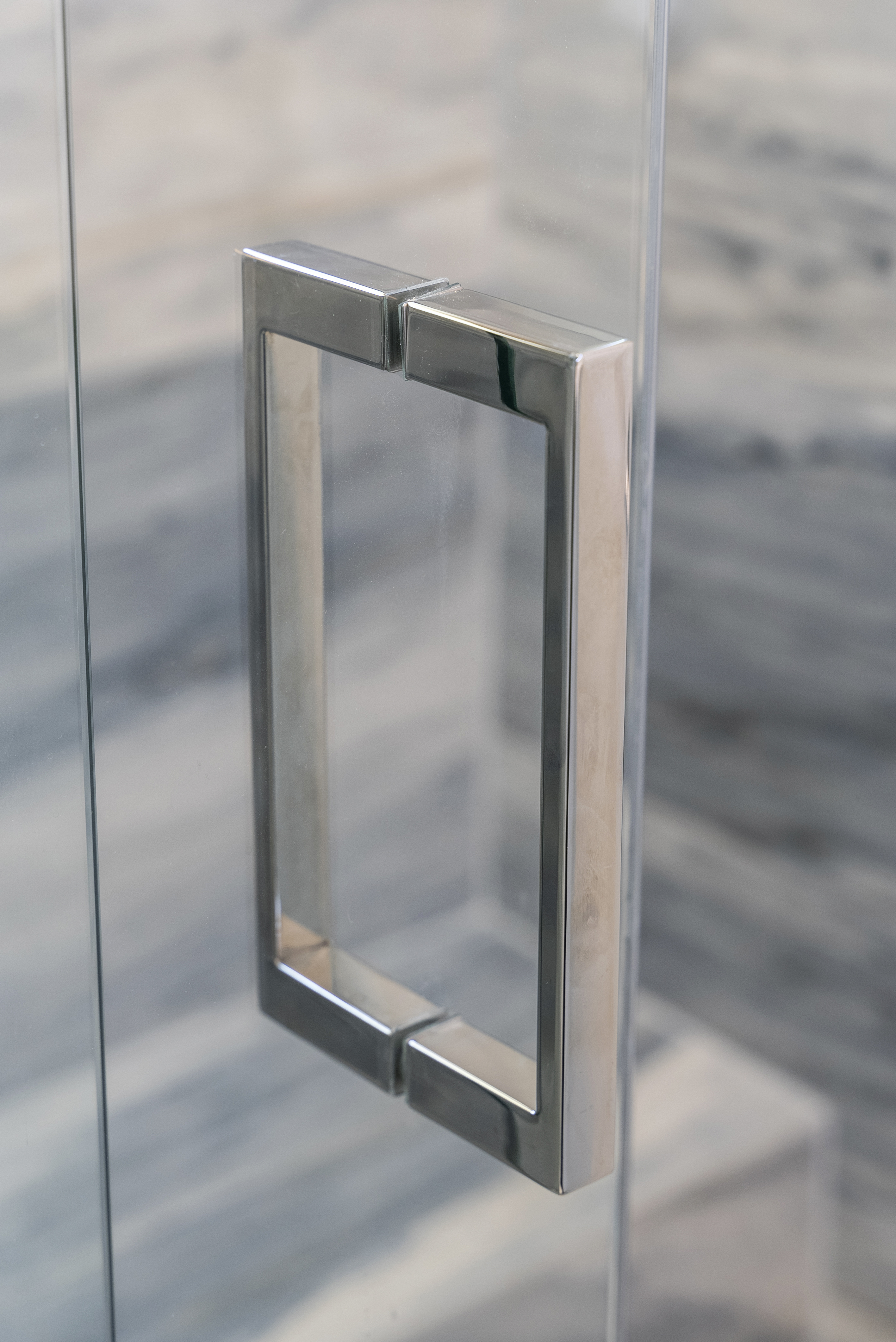 Sleek metal handle on glass shower door