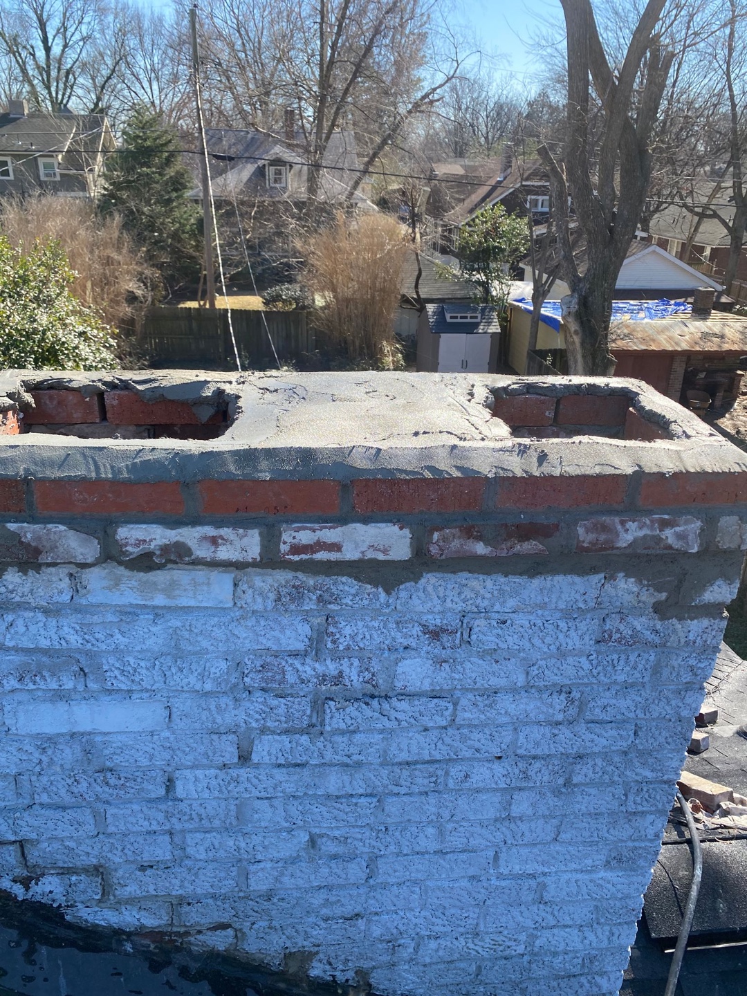 Top section of repaired brick chimney with new mortar and bricks