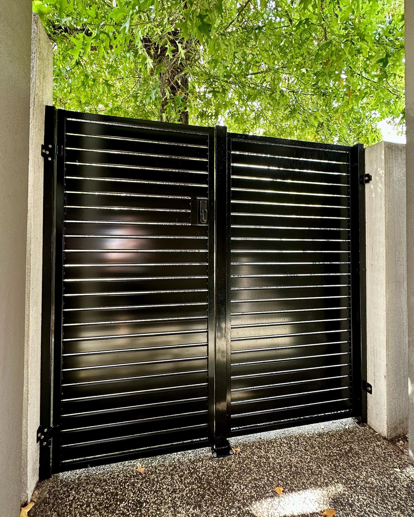 Black metal gate framed by concrete pillars