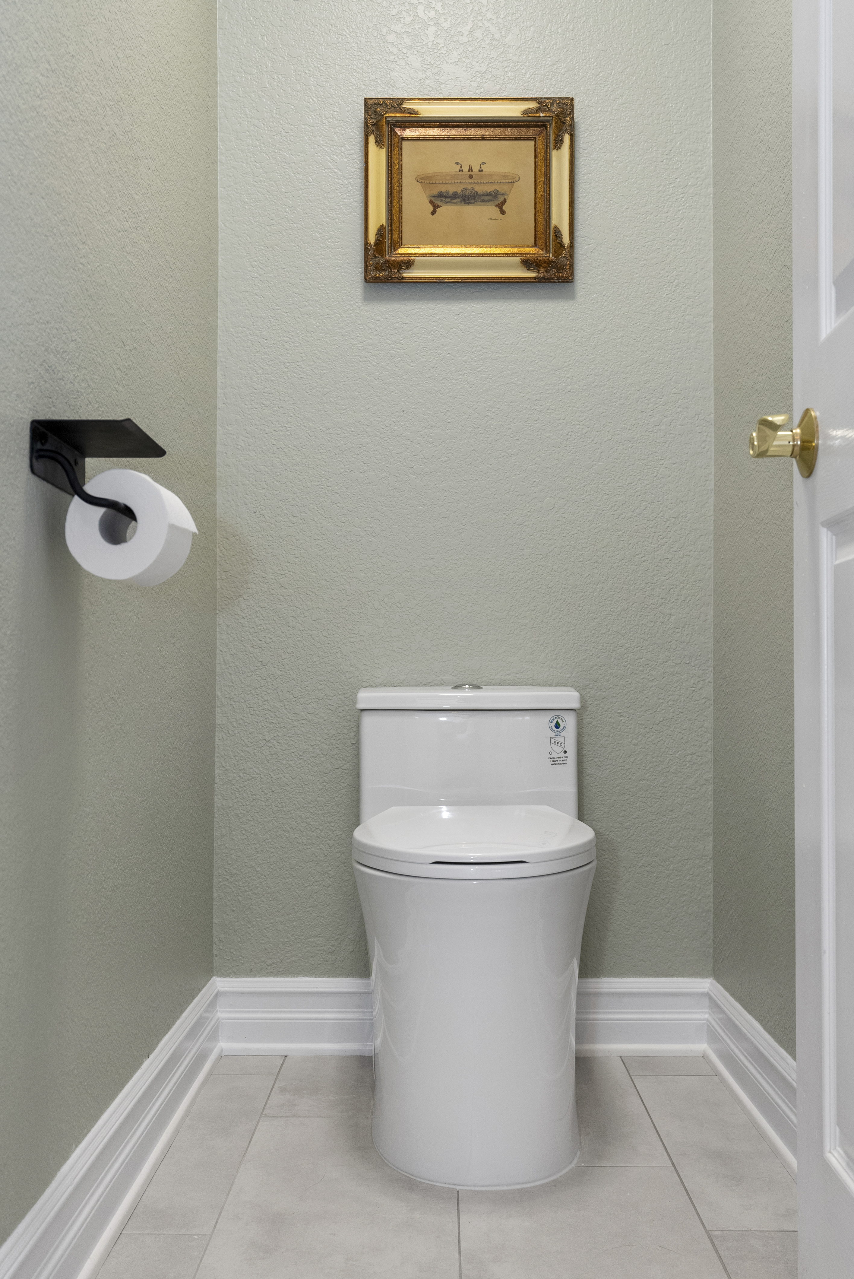 Modern white toilet against light green wall