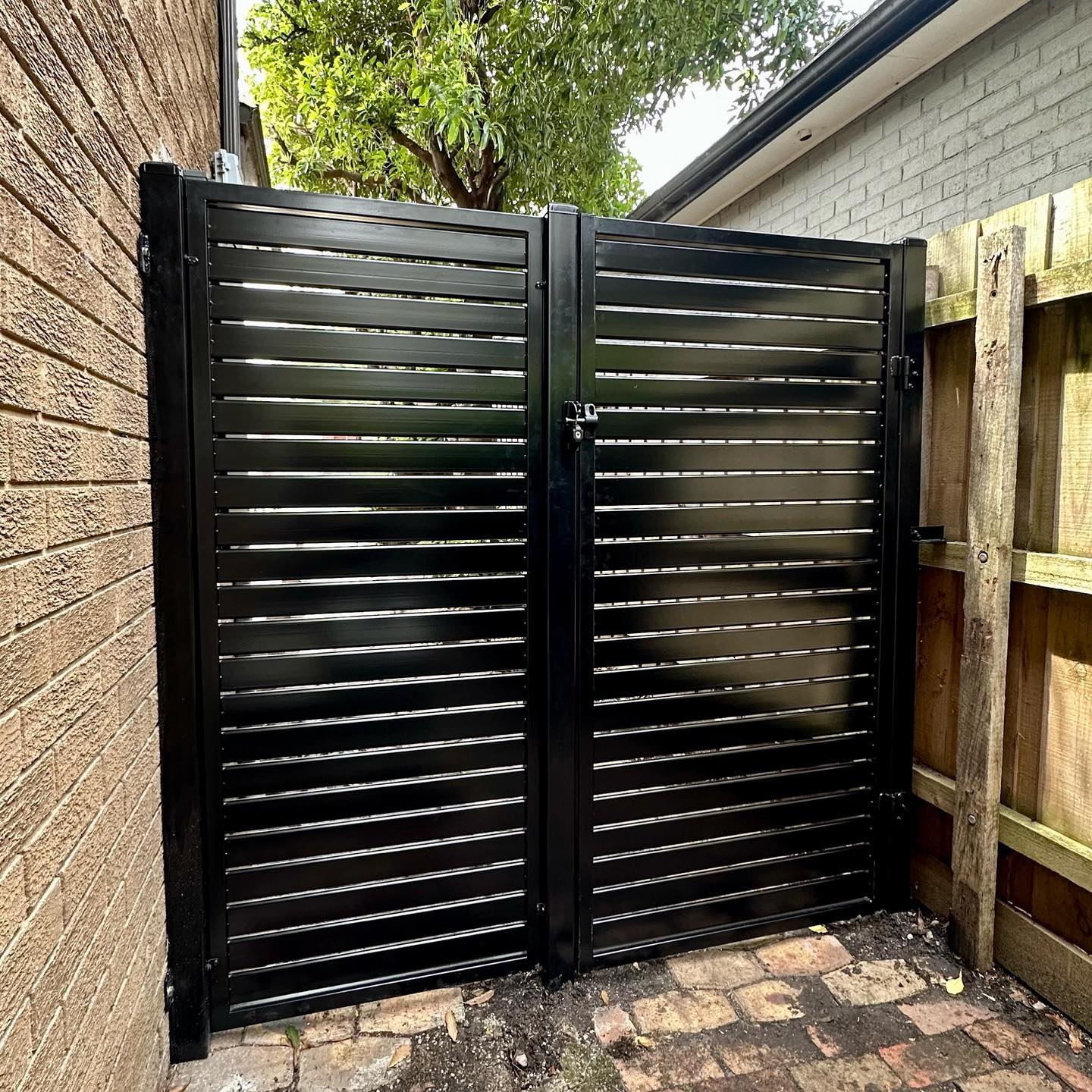 Black slat steel fence panels forming a gate