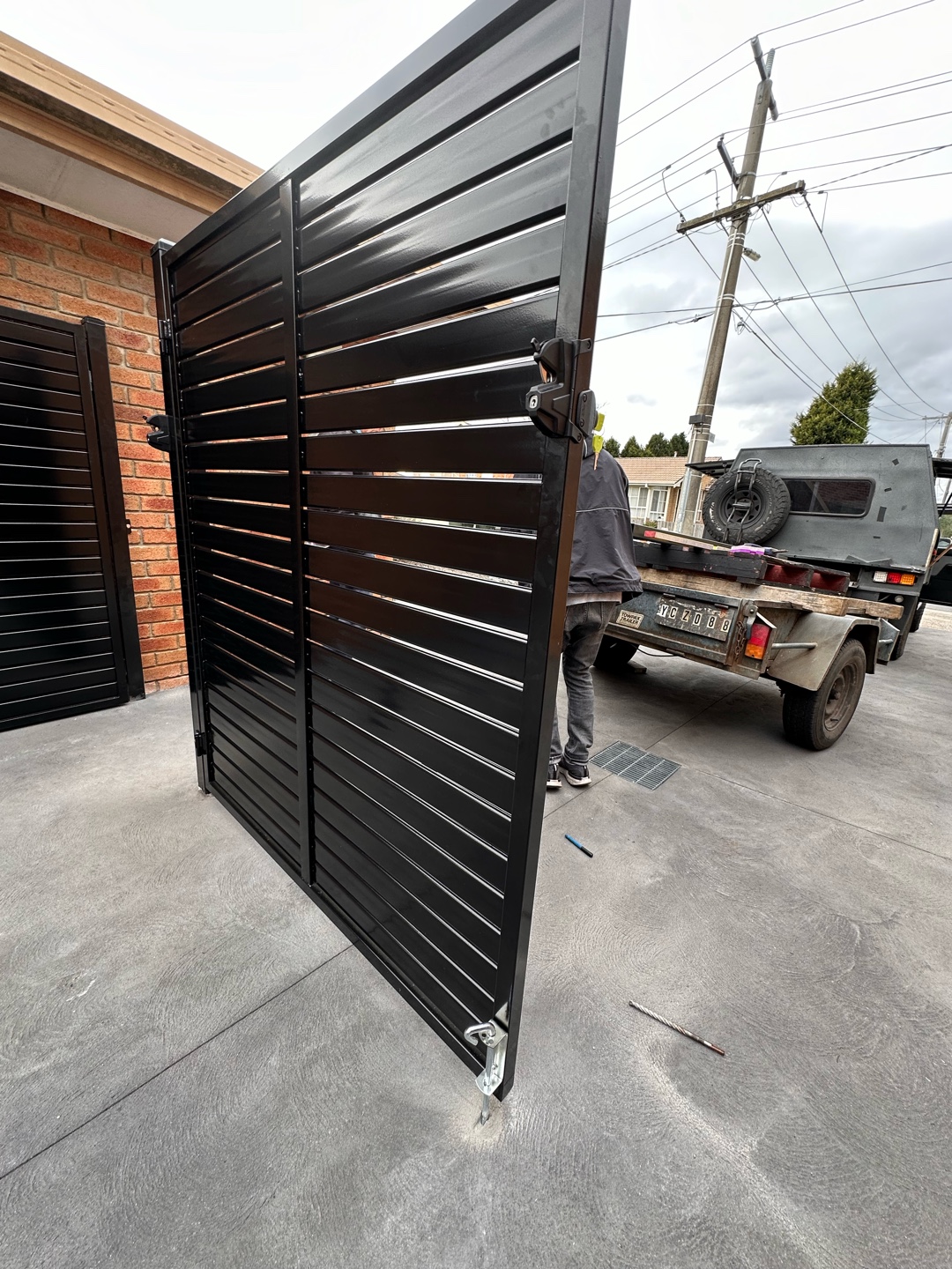 Partially open black slat screen double gate