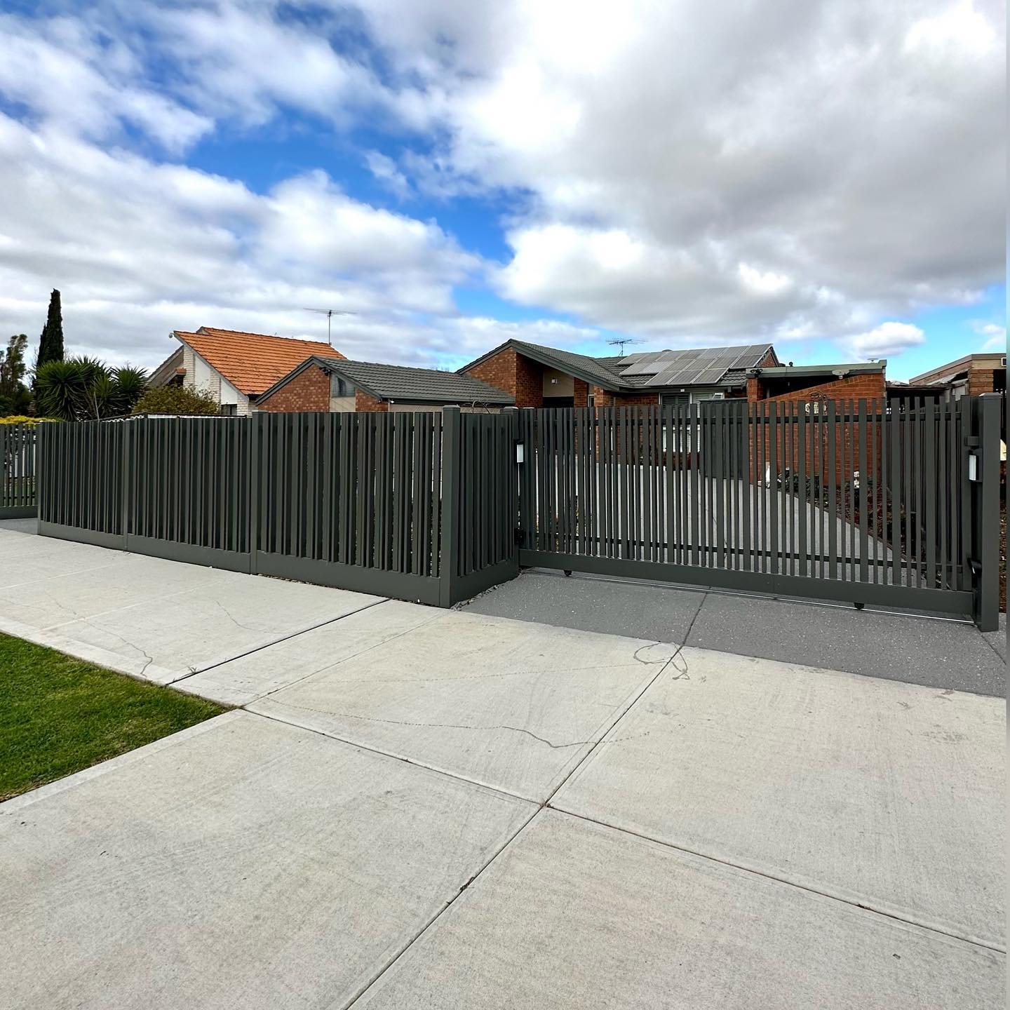 Modern grey metal fence with automated gate