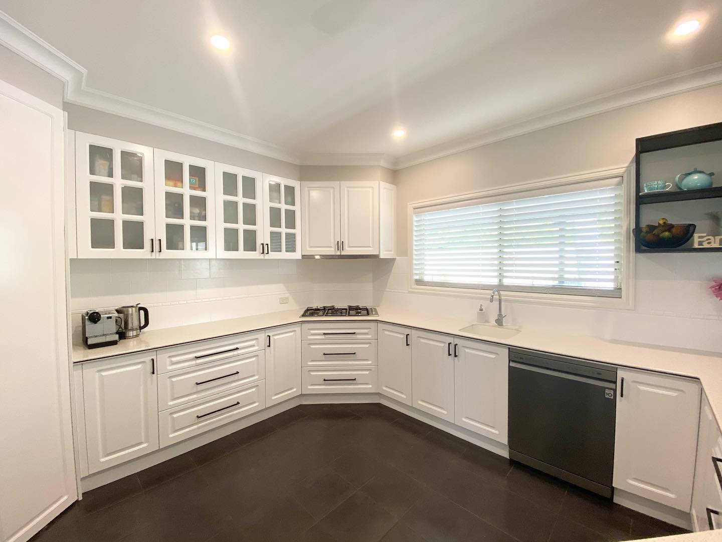 White cabinetry with glass doors after resurfacing