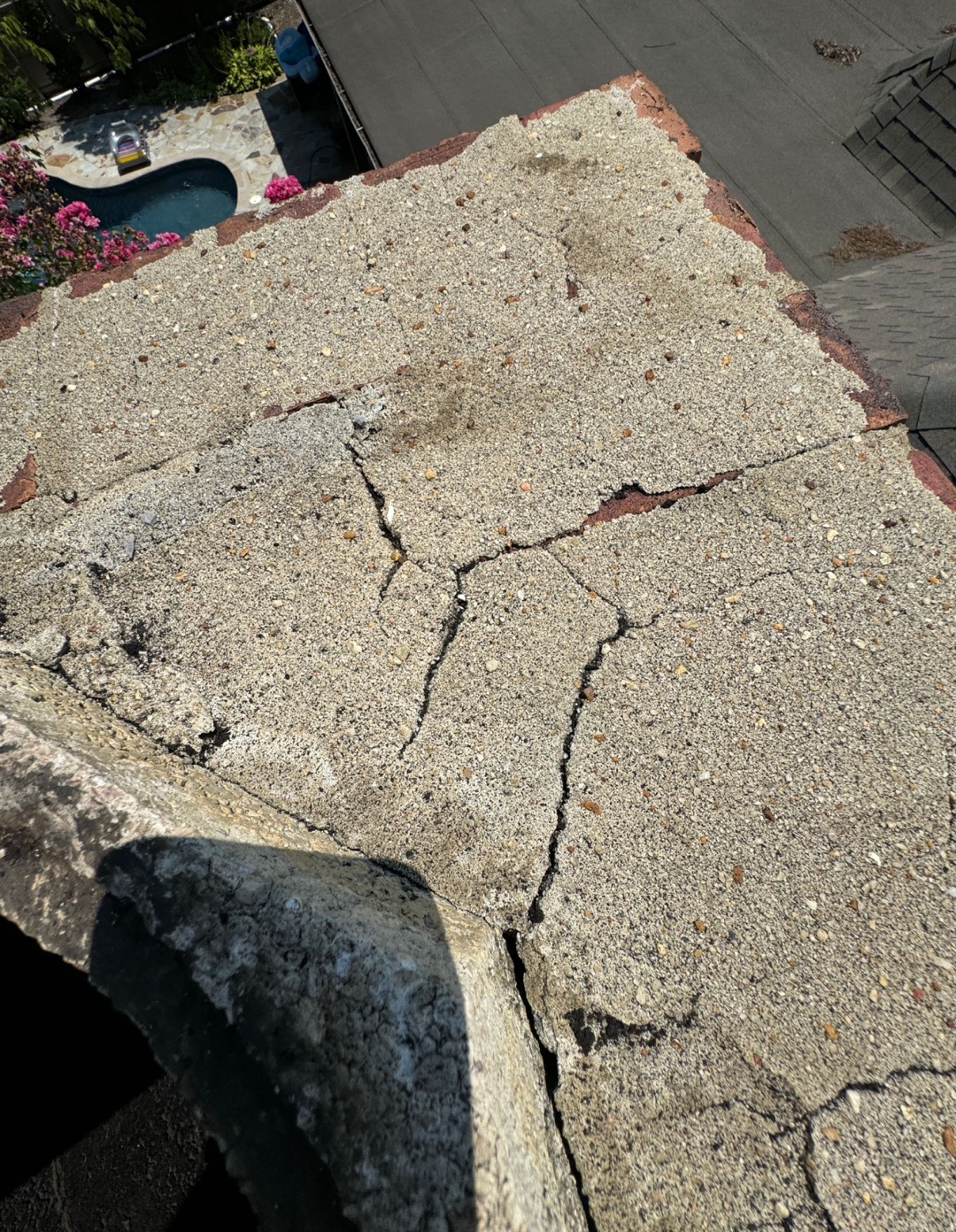 Top view of a cracked and deteriorating chimney crown