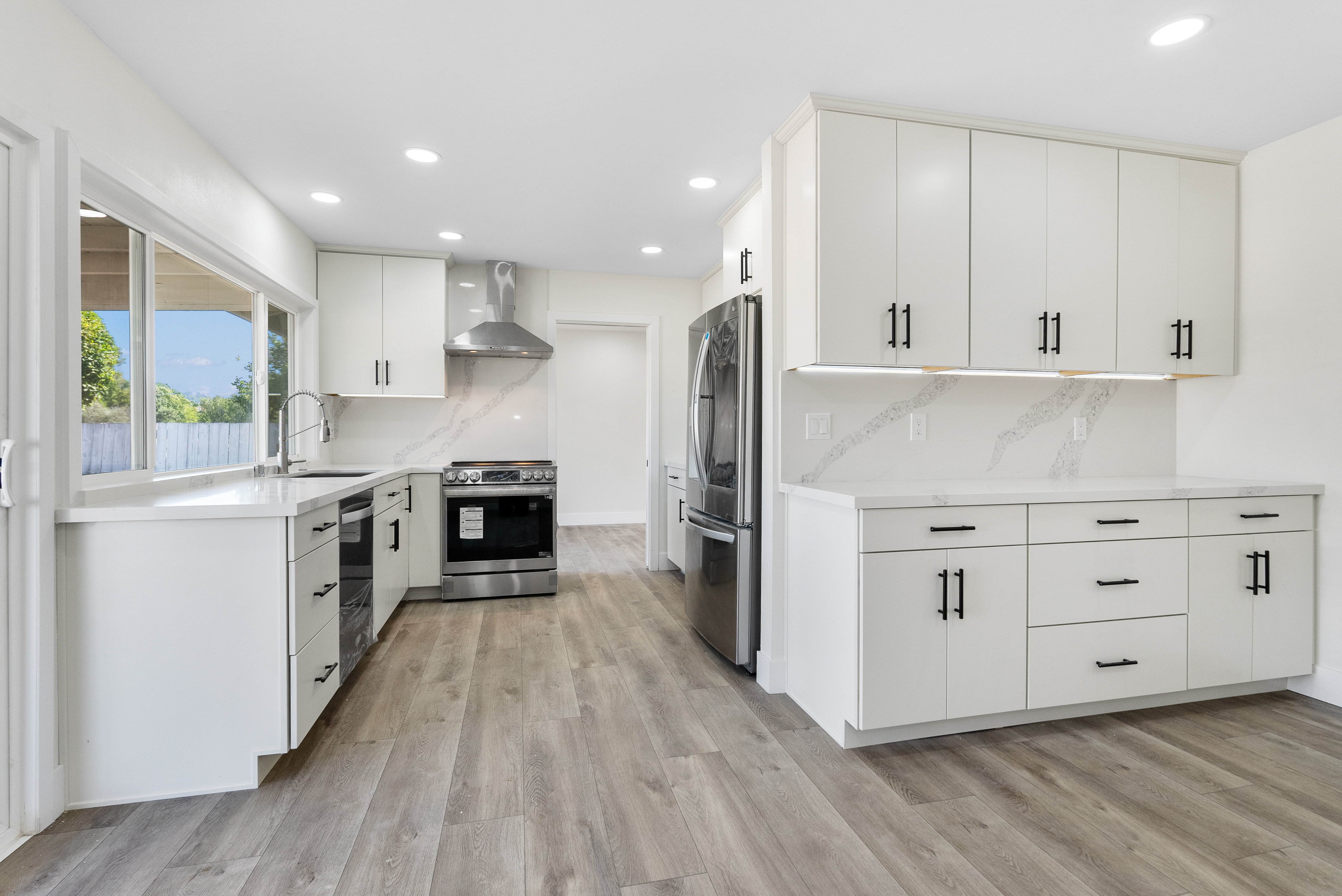 Modern kitchen with white cabinetry and black handles